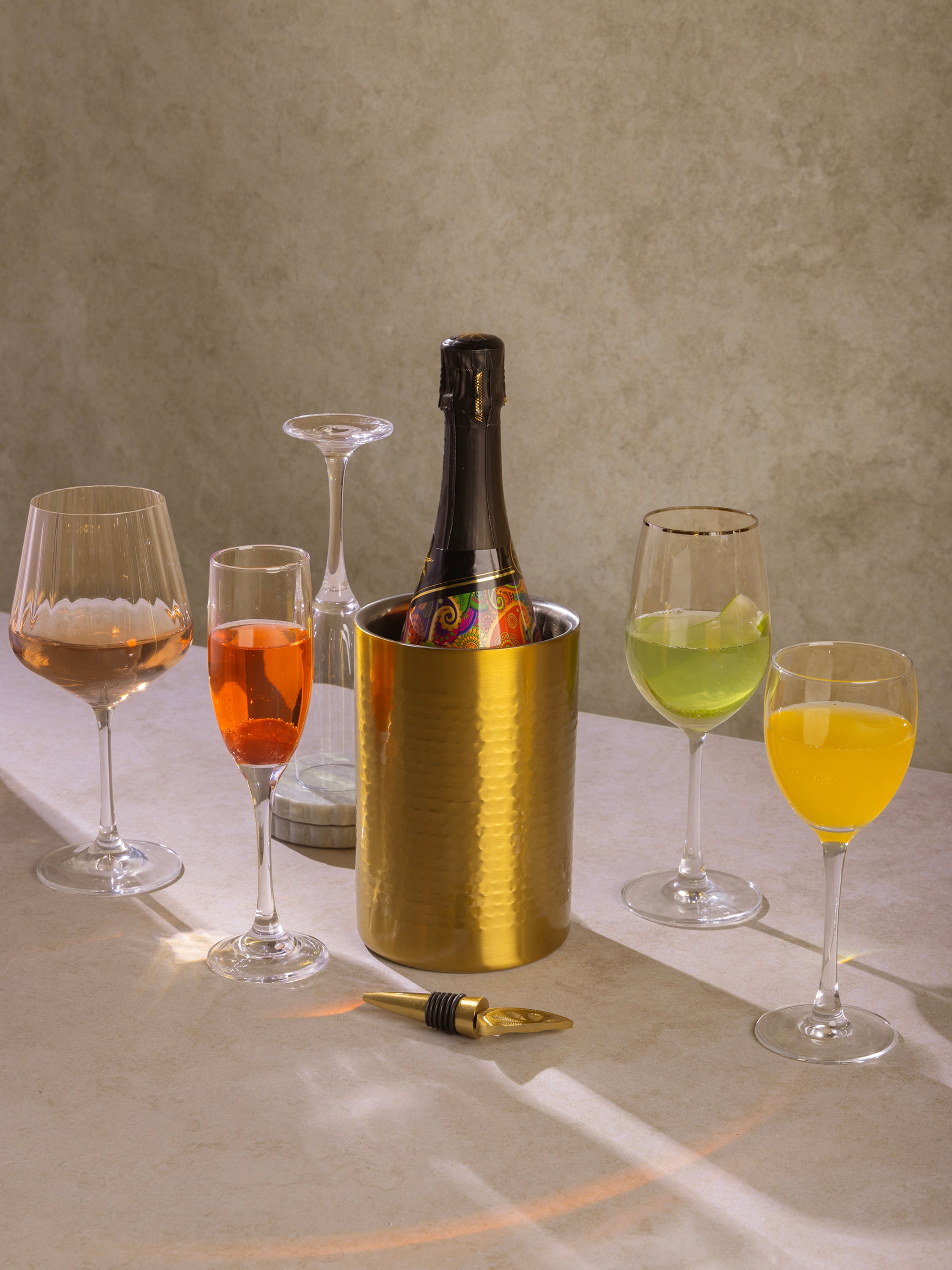 Sculptural gold stainless steel wine chiller in cylindrical form — refined entertaining piece