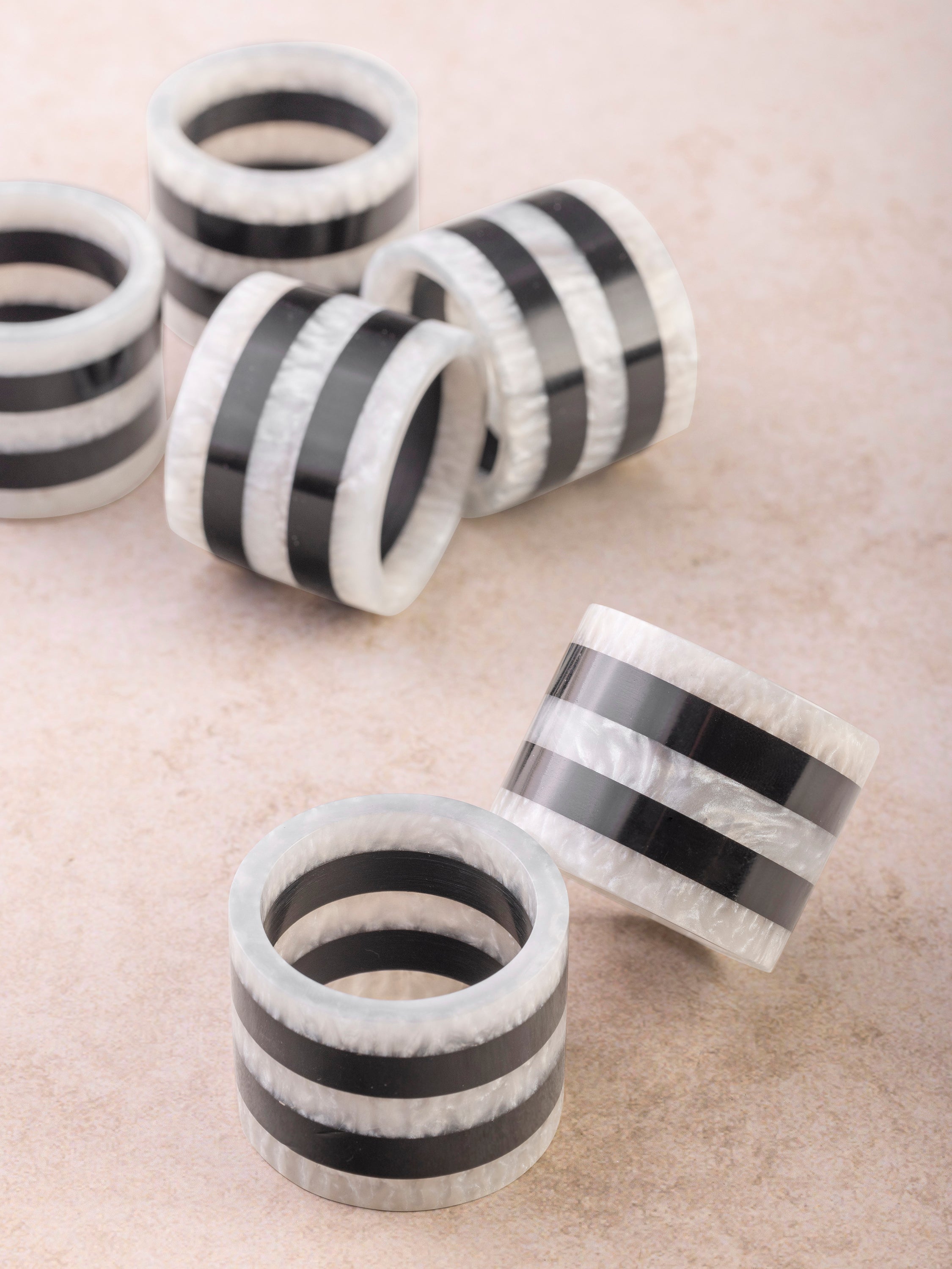 Handcrafted resin napkin rings in pearl white and black two-tone finish — artisan luxury table accent
