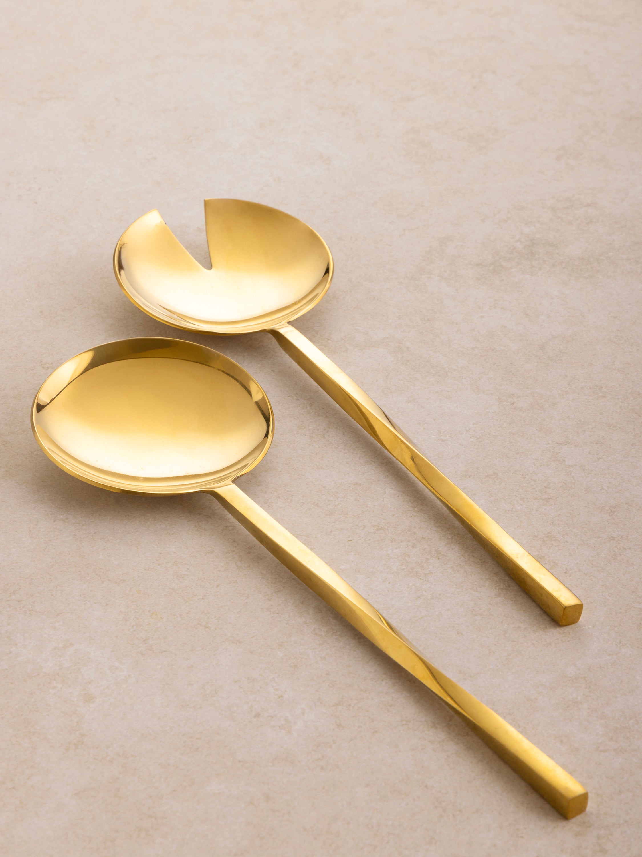 Oslo salad server pair arranged together, featuring elongated handles and smooth rounded heads in a minimal design.