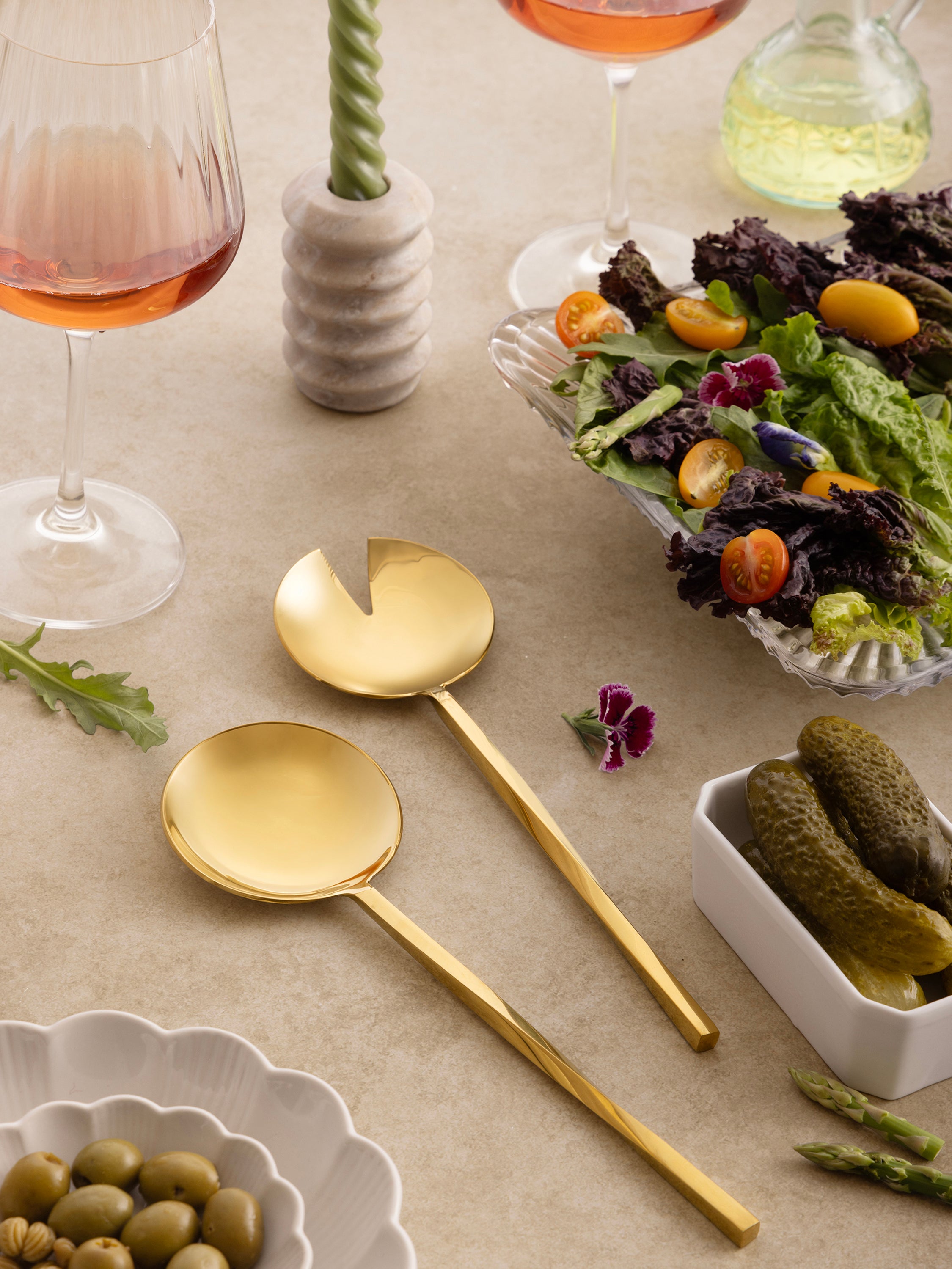 Warm gold salad spoon and fork with sculptural spiral handles — refined tableware