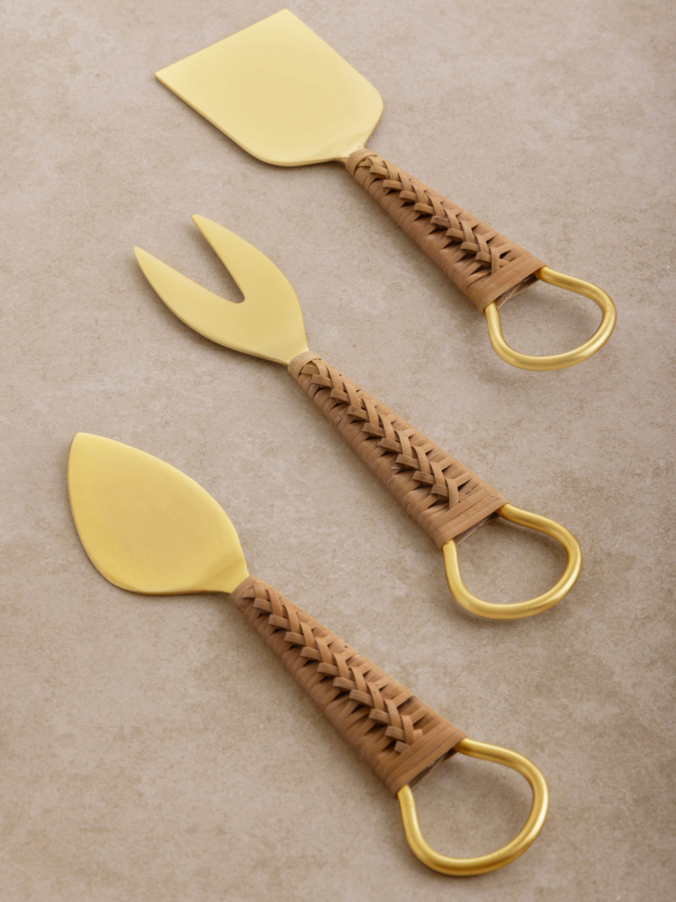 Cheese knife set in matte gold and rattan handles — artisan tableware essential