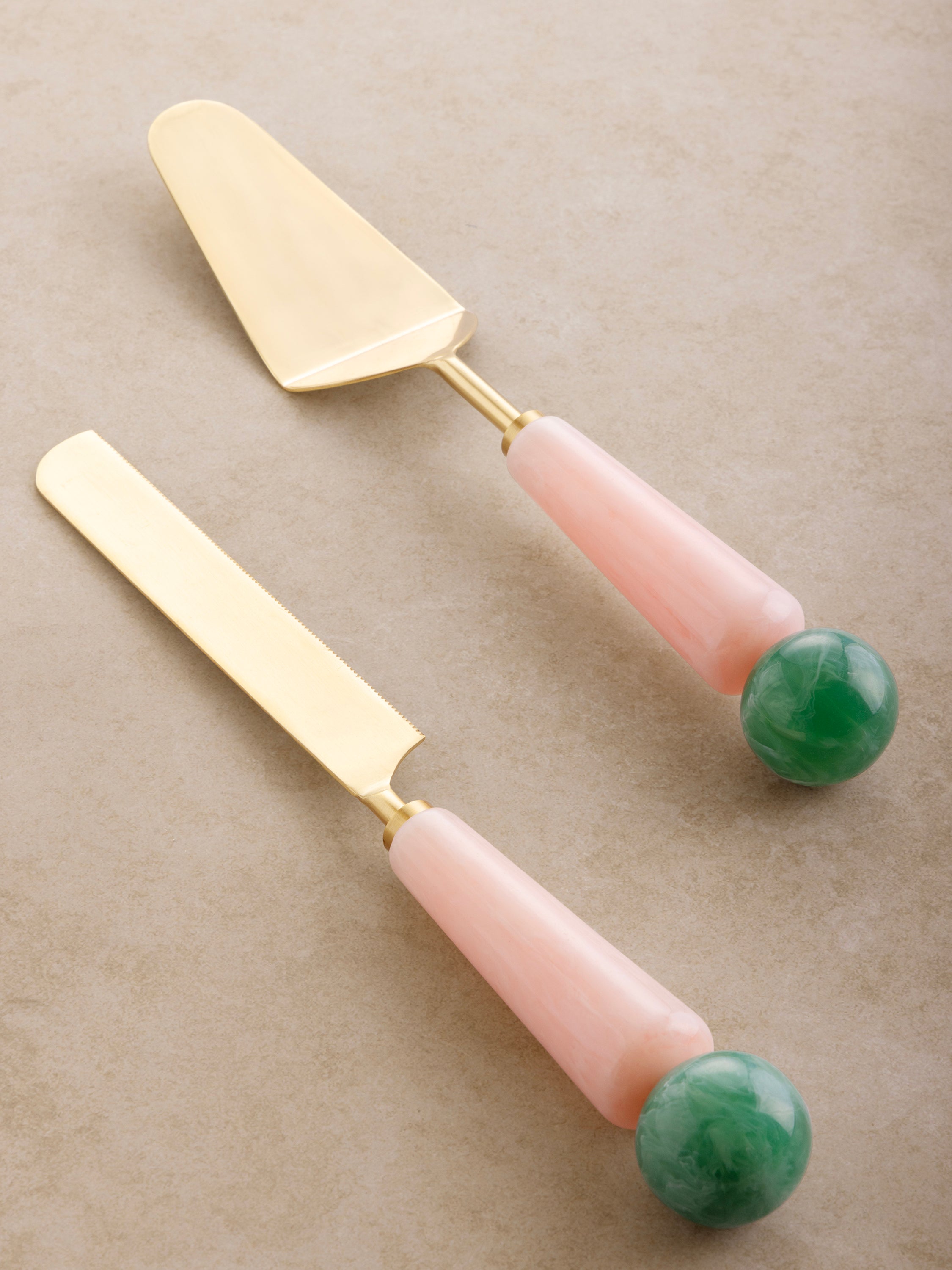 Matte gold cake servers with soft pink and pastel green resin handles — luxury serveware set of two