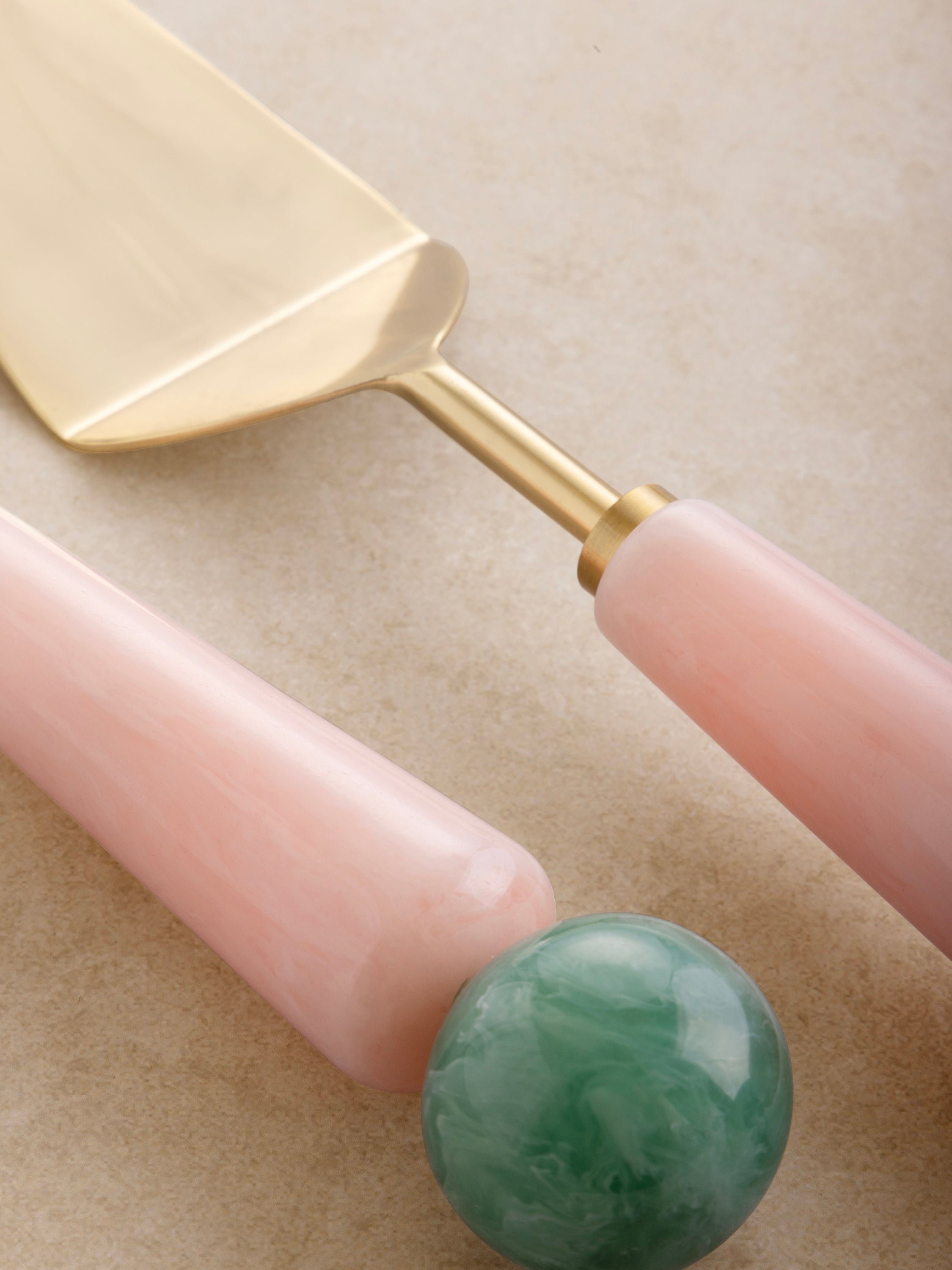 Soft gold dessert servers with marbled resin handles in pastel tones — modern artisan tableware