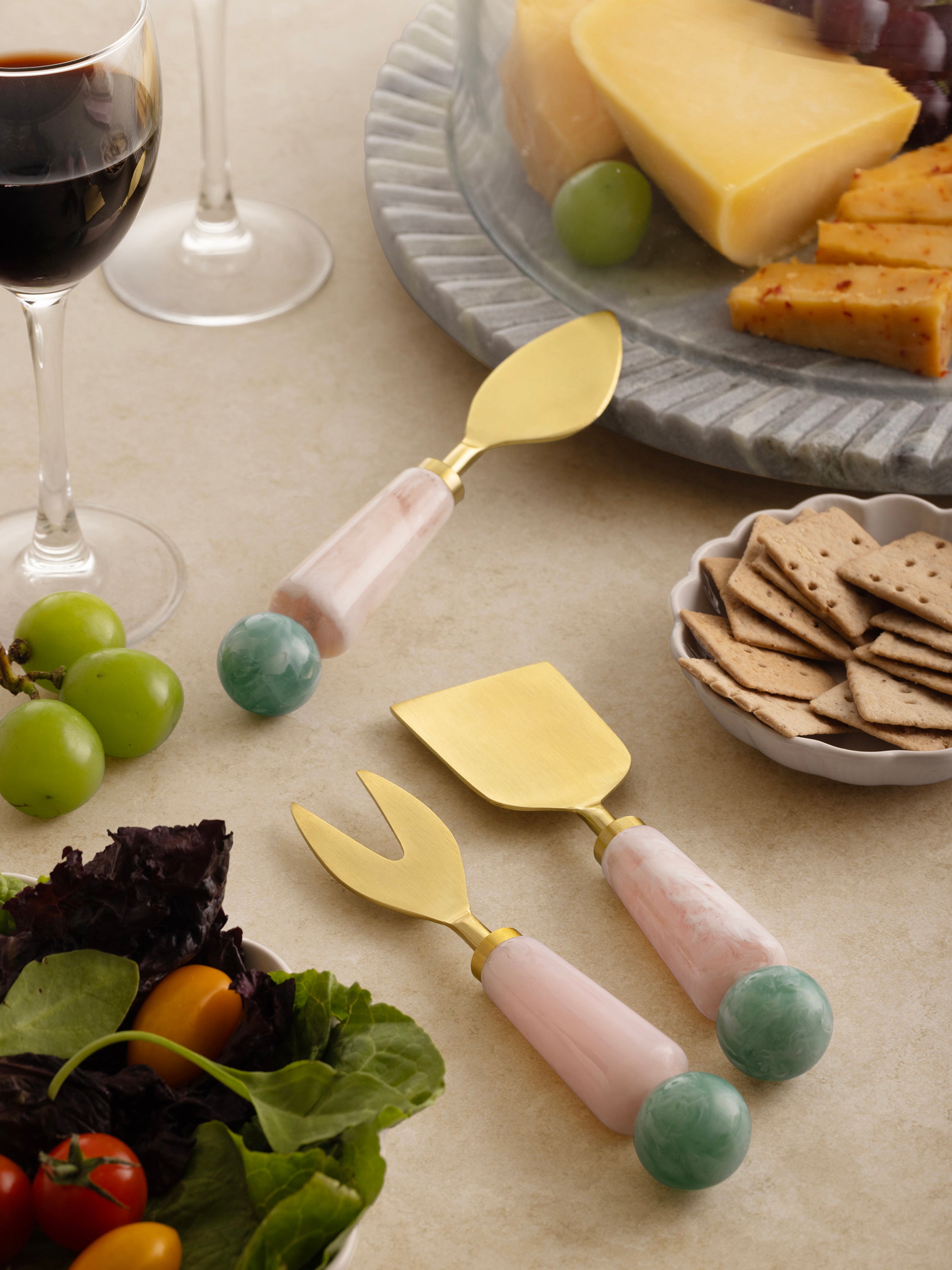 Set of three gold-finished cheese knives with colorful resin grips — refined table accessory