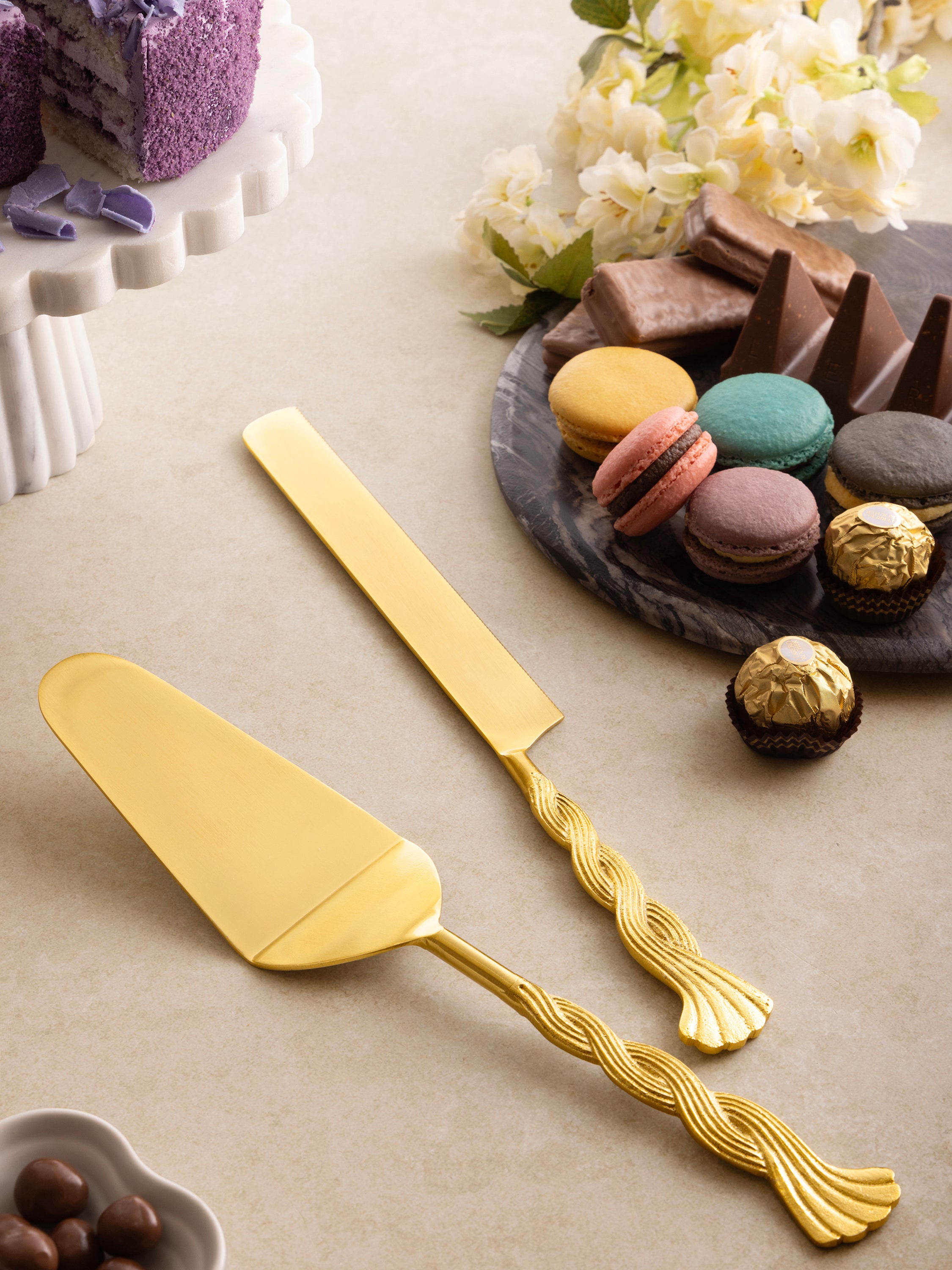 Twisted handle cake servers in matte gold — refined artisan tableware