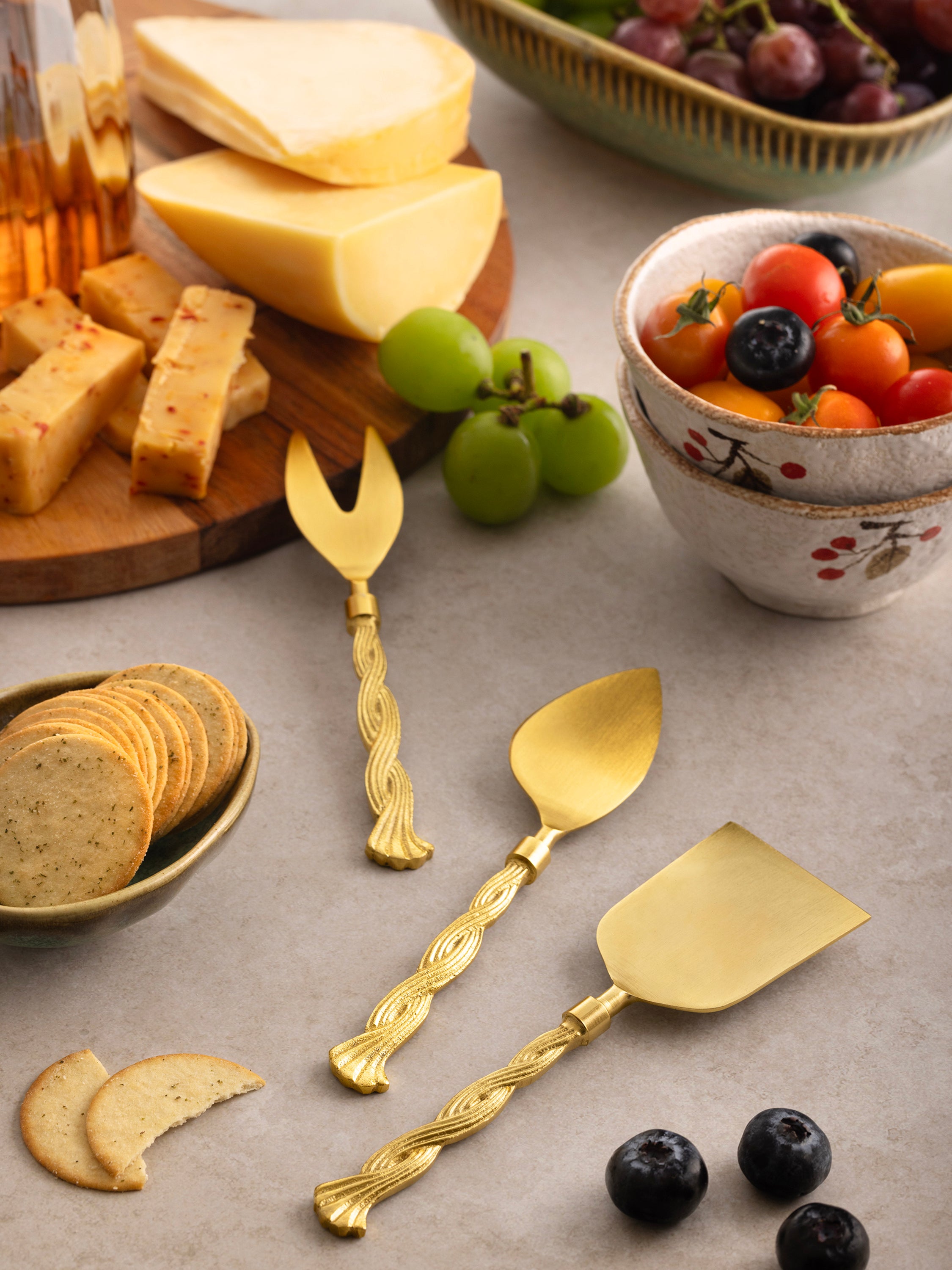 Gold-finish cheese knife trio with sculptural handles — elegant table accessory
