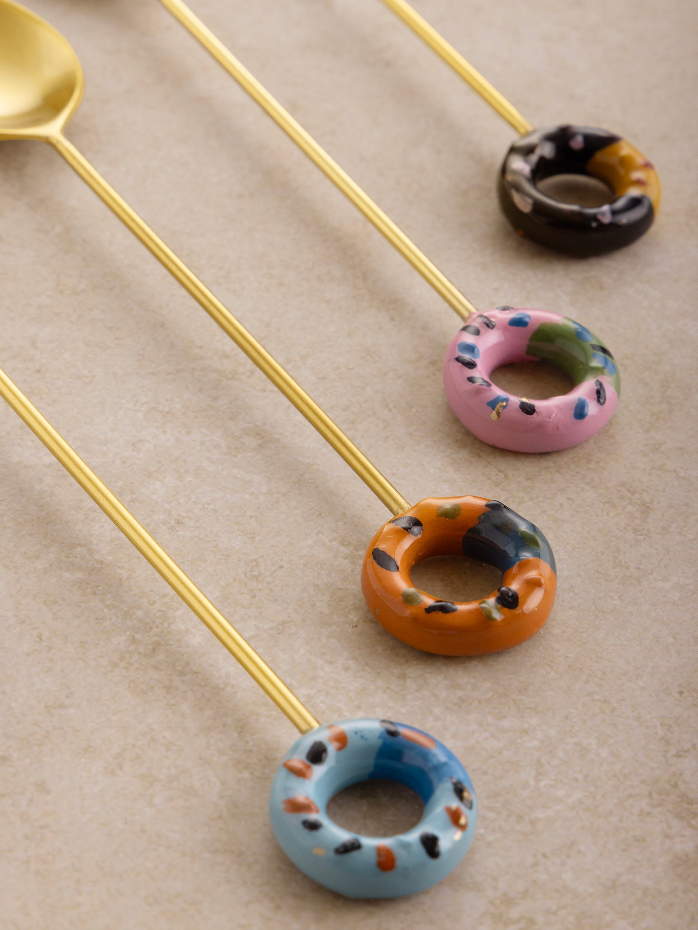 Luxurious stainless steel teaspoons with artistic donut-inspired handles in assorted colors