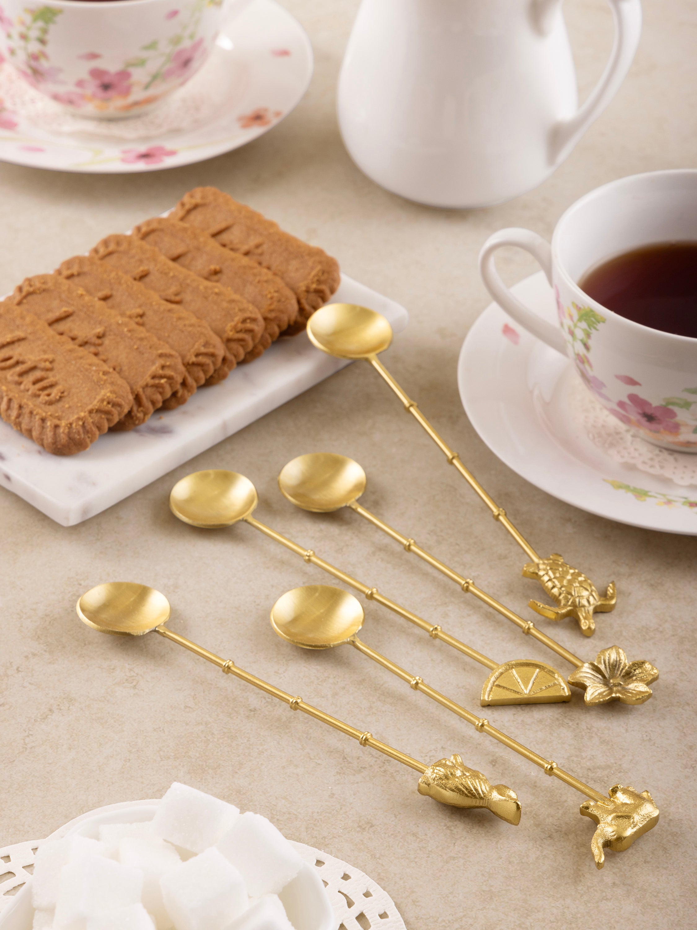 Luxurious gold-tone dessert spoons featuring intricate animal and floral designs