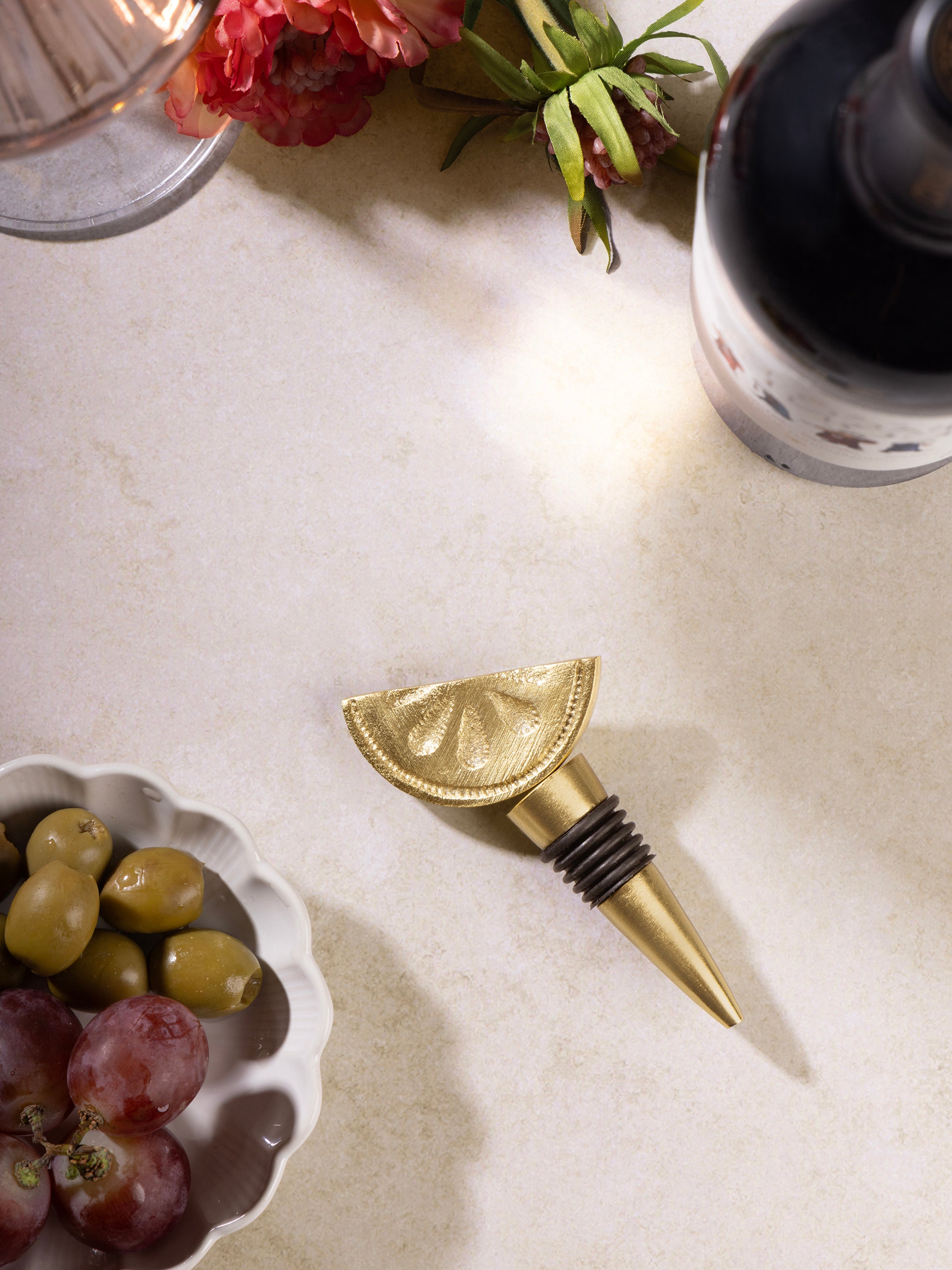 Wine stopper in matte gold finish with subtle texture pattern — refined home bar detail