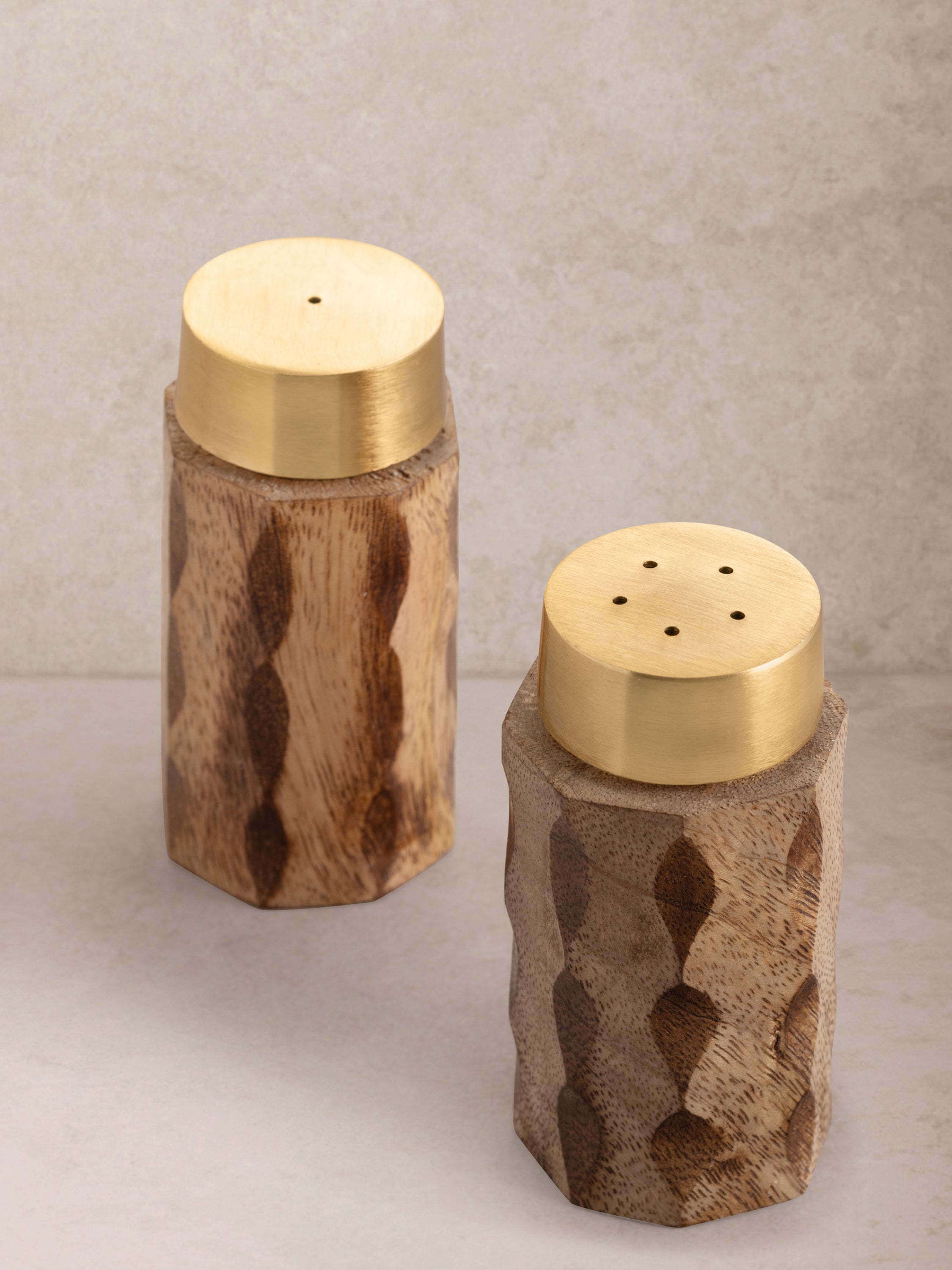 Handcrafted wooden salt and pepper shakers with brushed matte-gold tops — artisan dining essentials