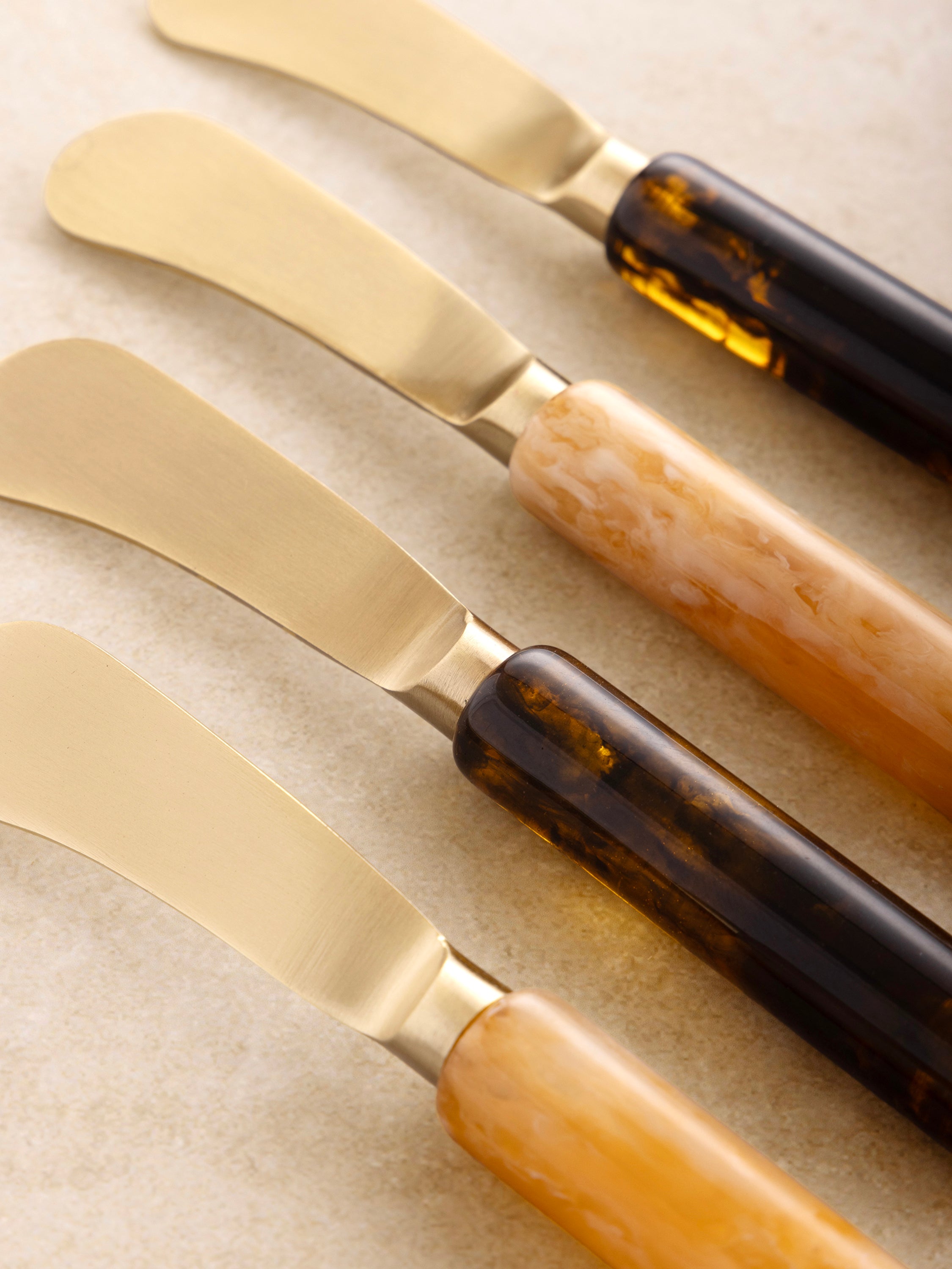 Artisan resin-handled butter knife set on linen-draped table