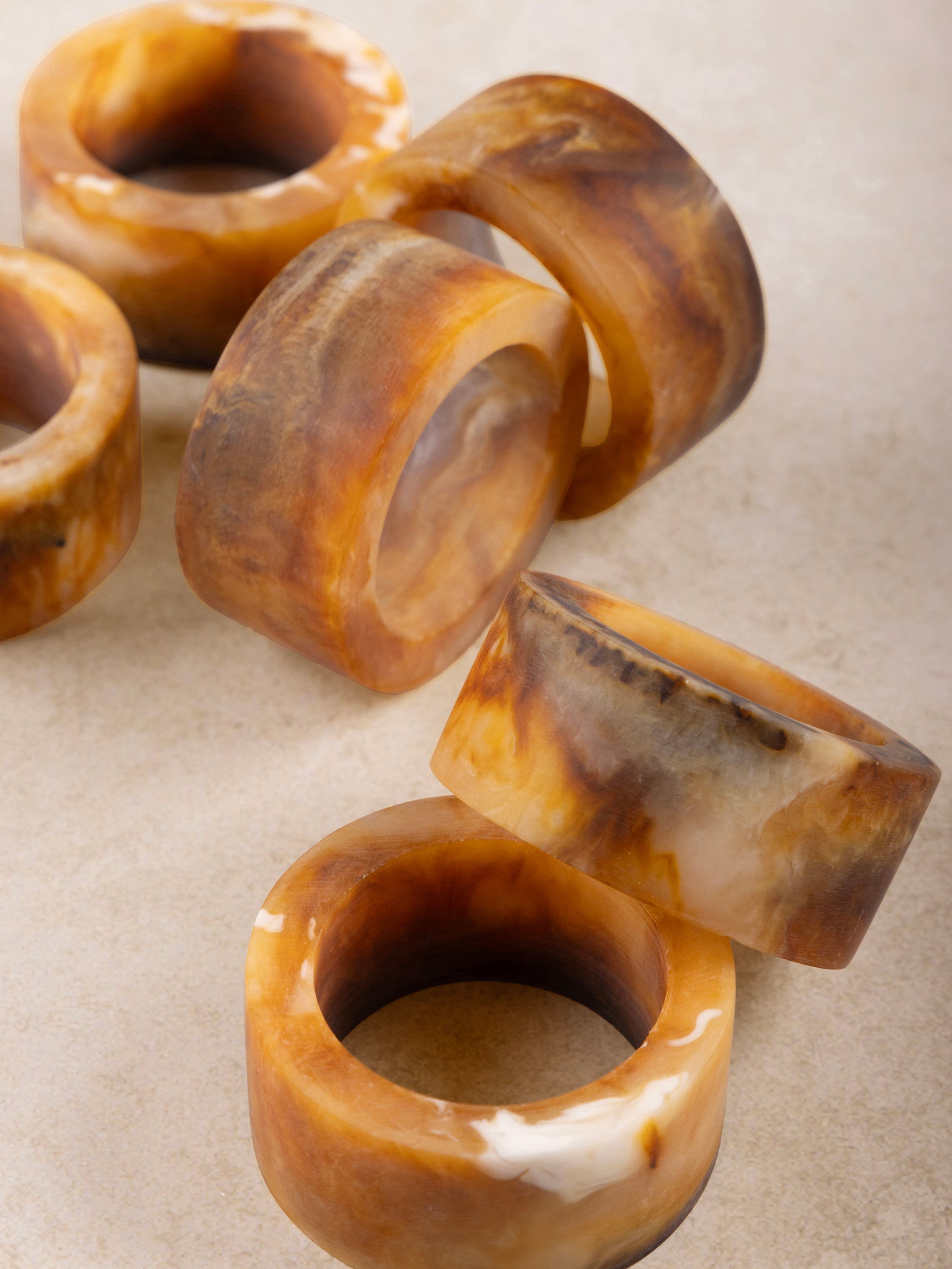 Set of six artisan resin napkin rings in brown tones for dining table