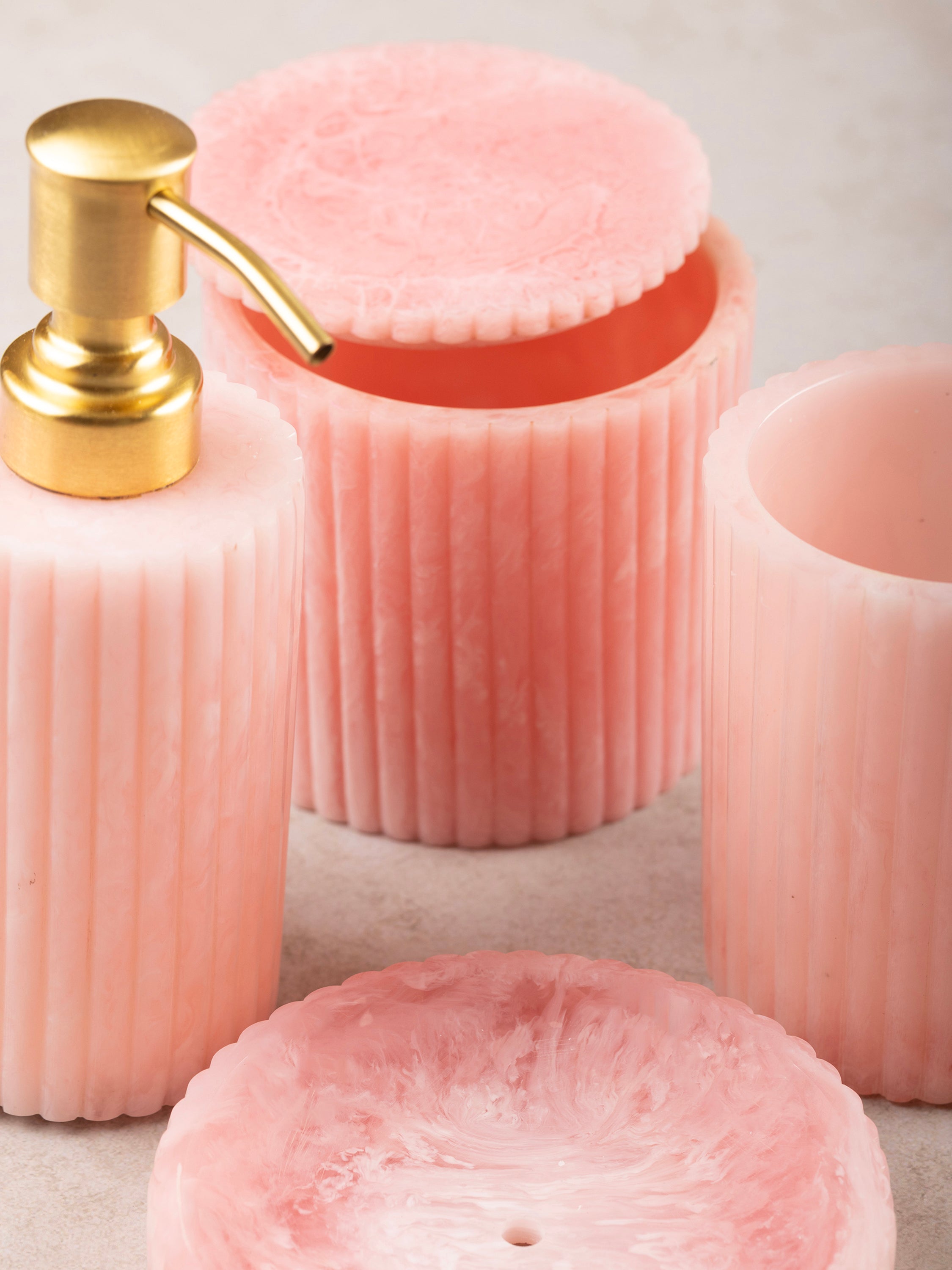 Chic pink bathroom organizer set with a sleek gold pump dispenser