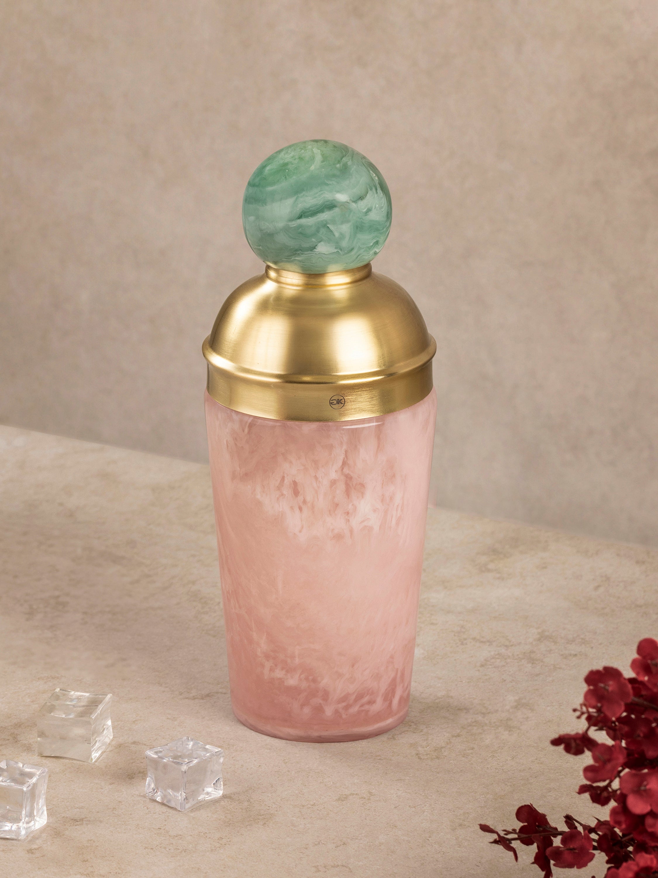 Copenhagen cocktail shaker shown with brass strainer lid and green knob, highlighting material contrast and architectural form