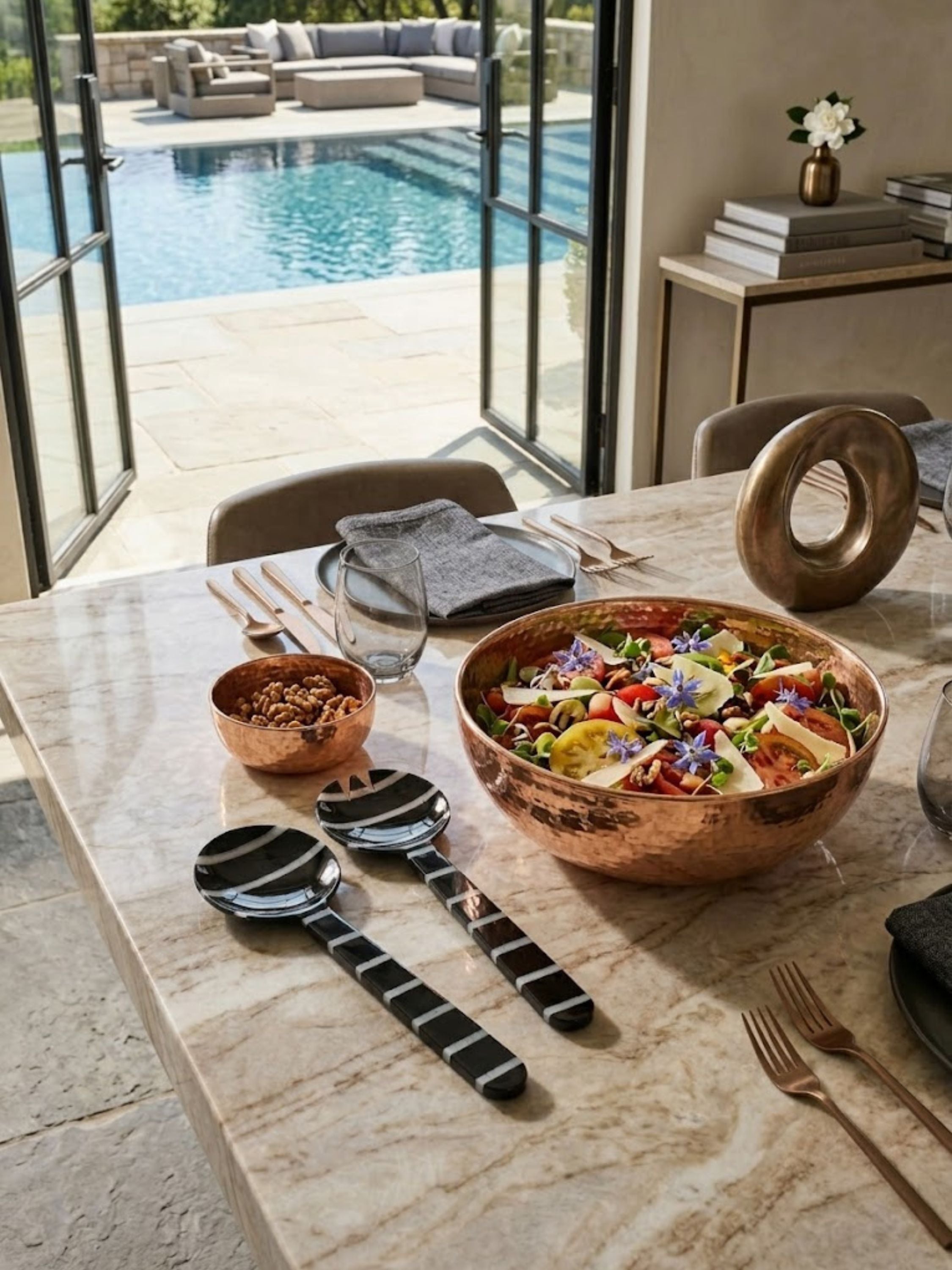 Cox resin salad servers styled beside a vibrant serving bowl in a light-filled indoor-outdoor dining setting, bringing graphic contrast and refined entertaining appeal.