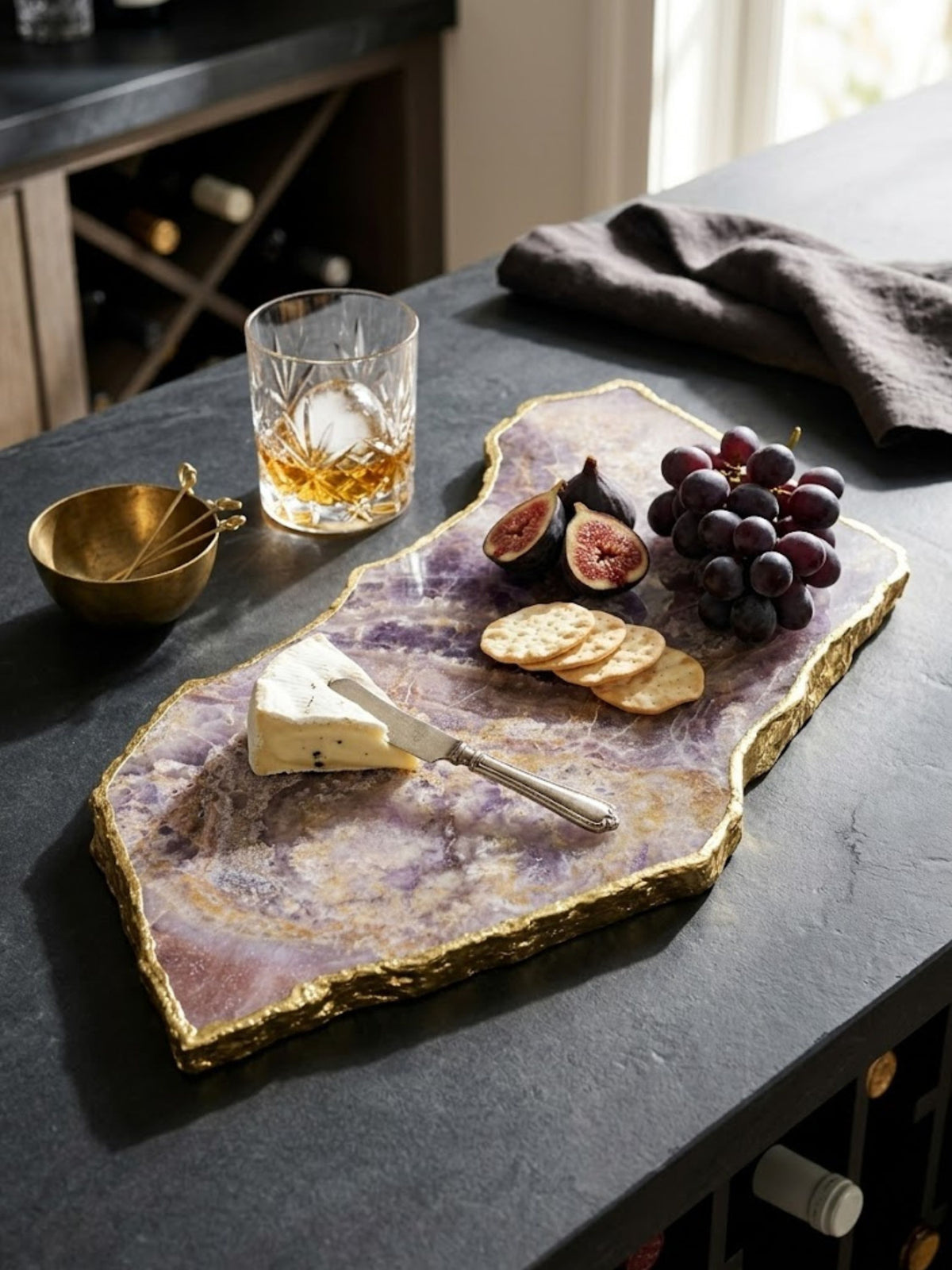 Amethyst stone cheese board with a polished, smooth surface, styled on a kitchen counter.