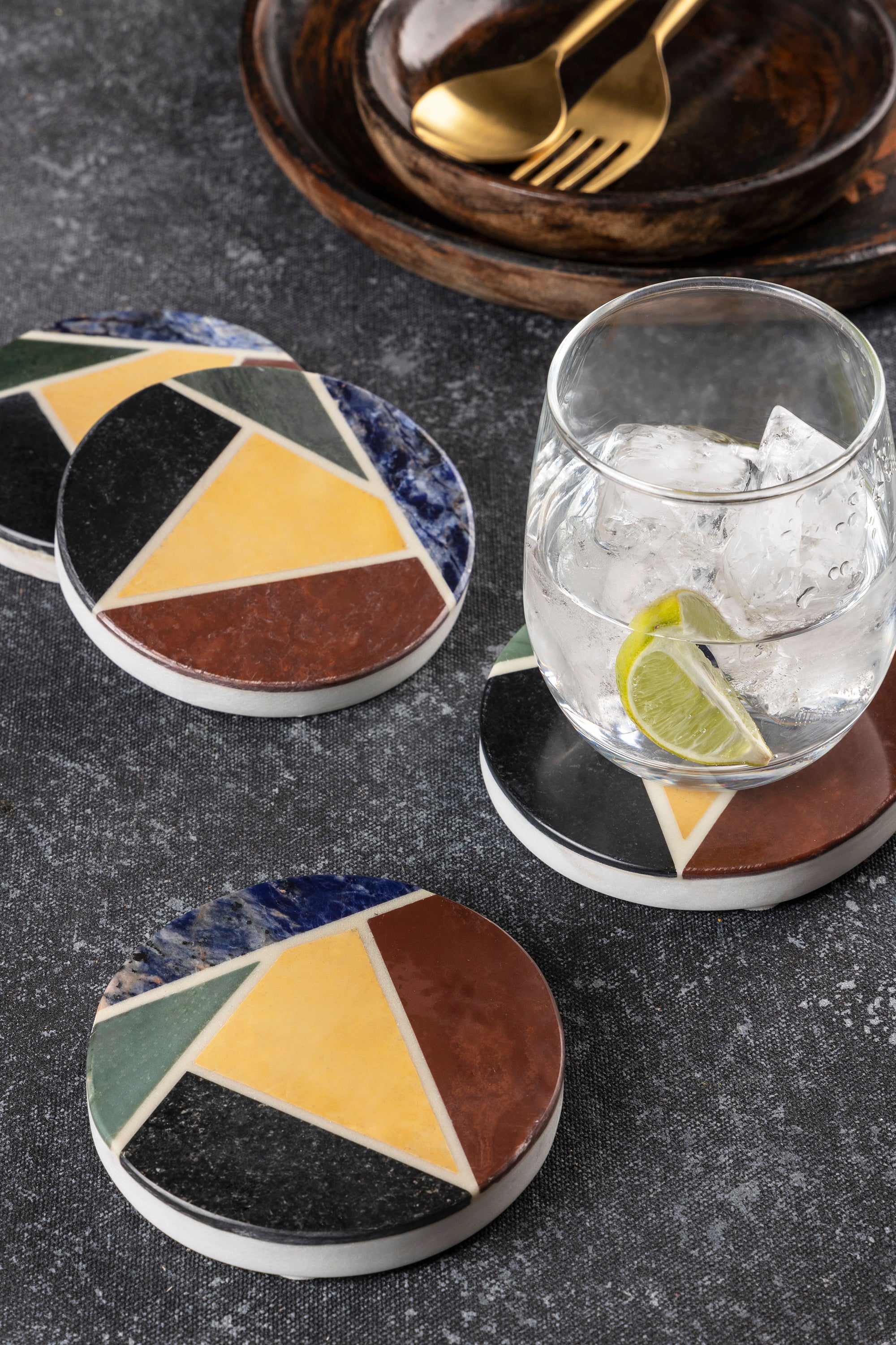 Polished natural-stone coasters set of four with vibrant inlaid patterns and rich texture