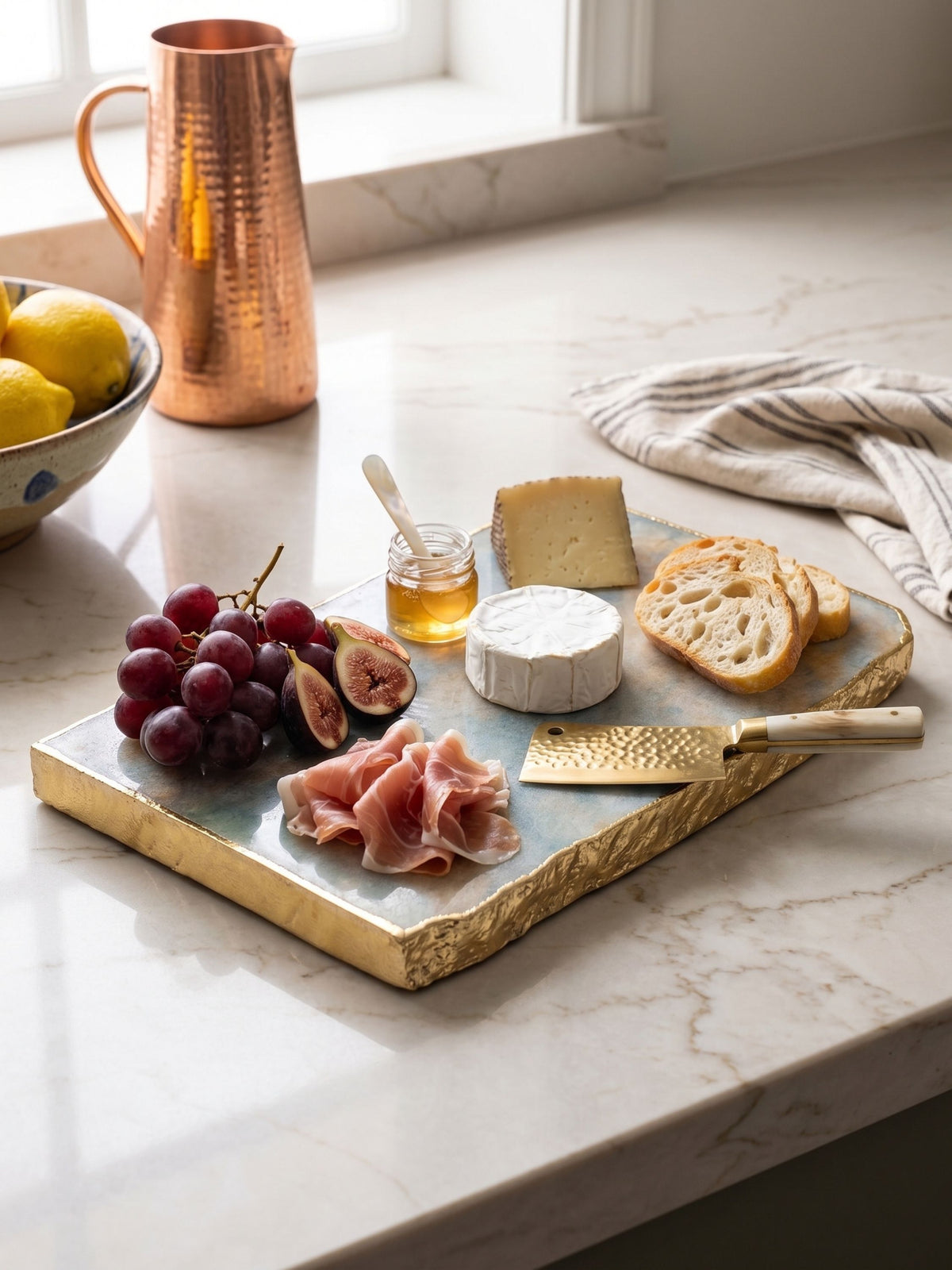 Aventurine cheese board styled with cheese and fruit for serving.