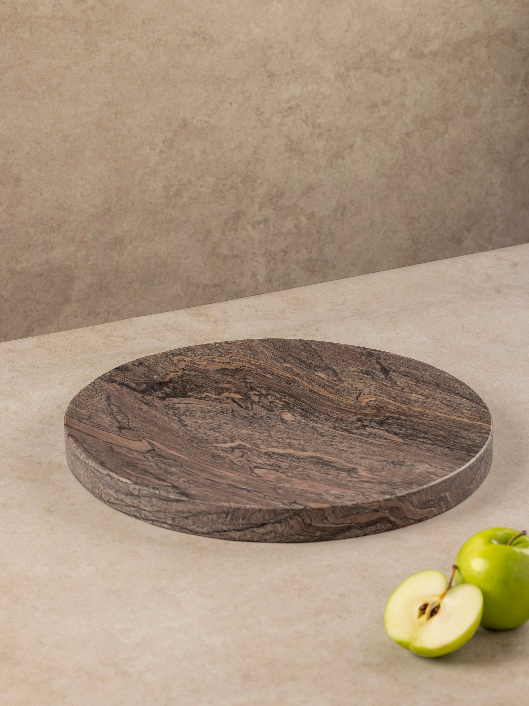 Round onyx tray in deep brown tones with layered natural veining and smooth surface, shown in a clean top-down composition