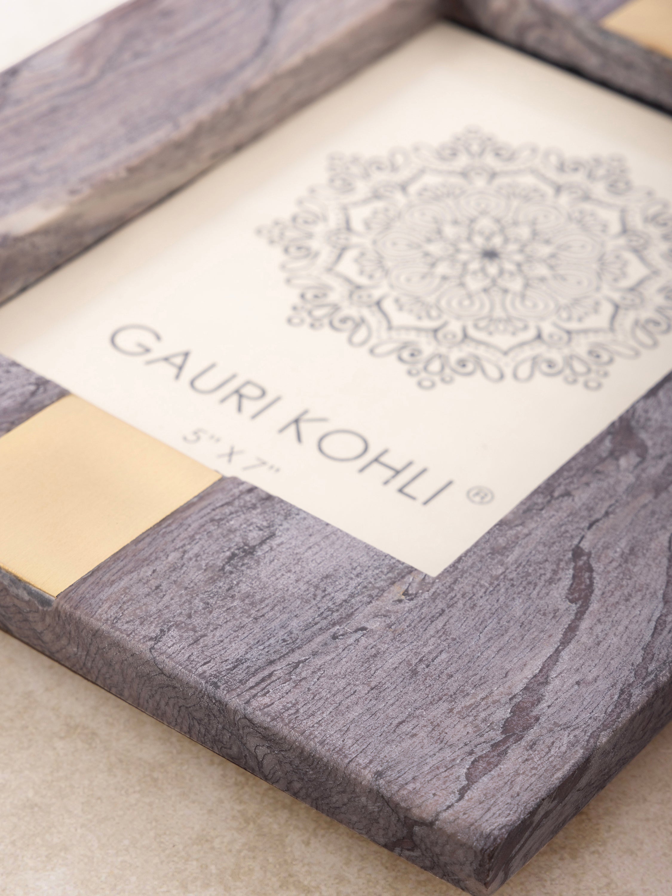 Close-up of purple onyx frame showing layered veining, polished surface, and brass inlay detail along the edge