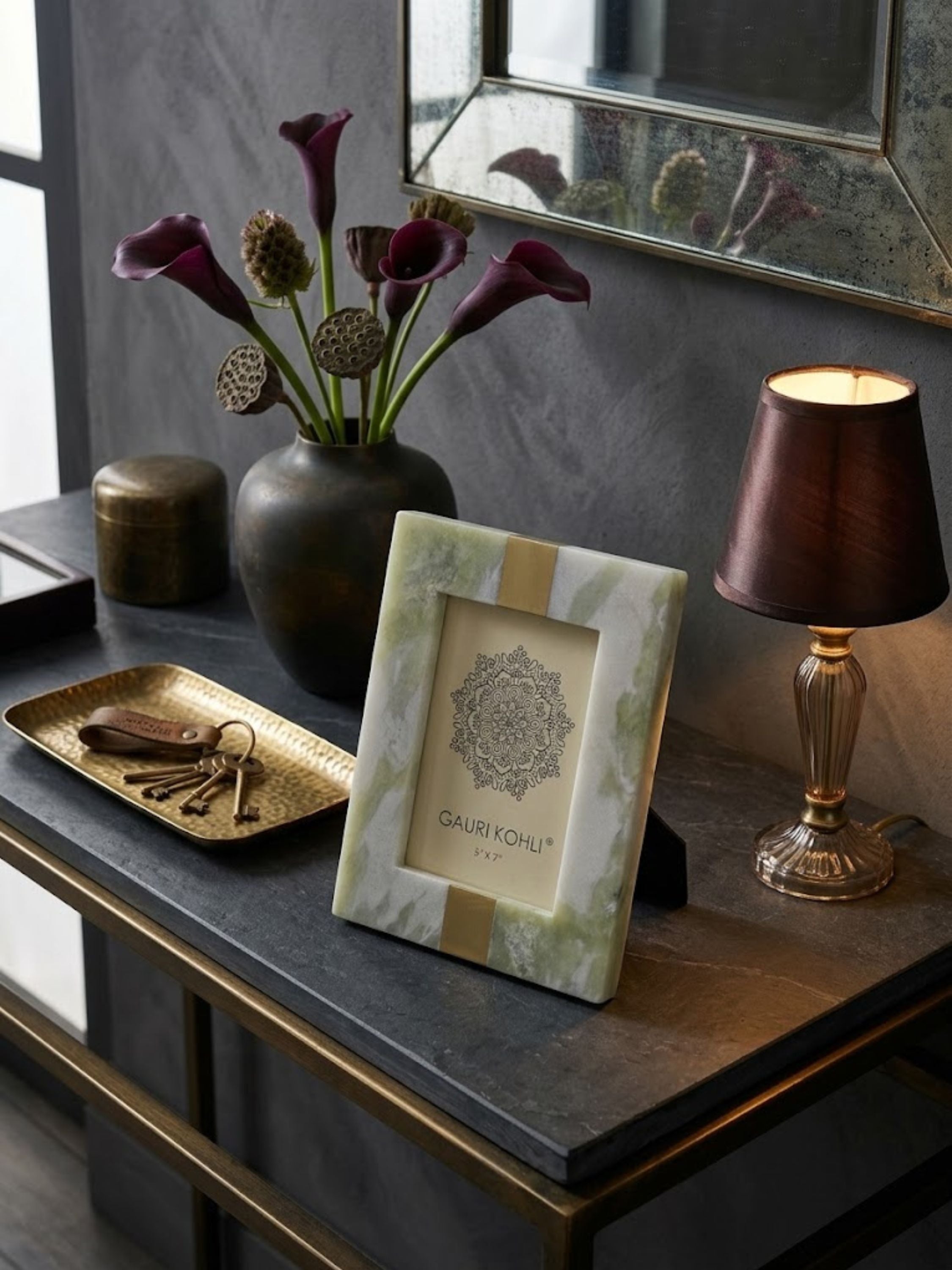Skye green onyx picture frame styled on a travertine console table with crystal accessories and brass accents, highlighting the stone’s luminous tonal movement.
