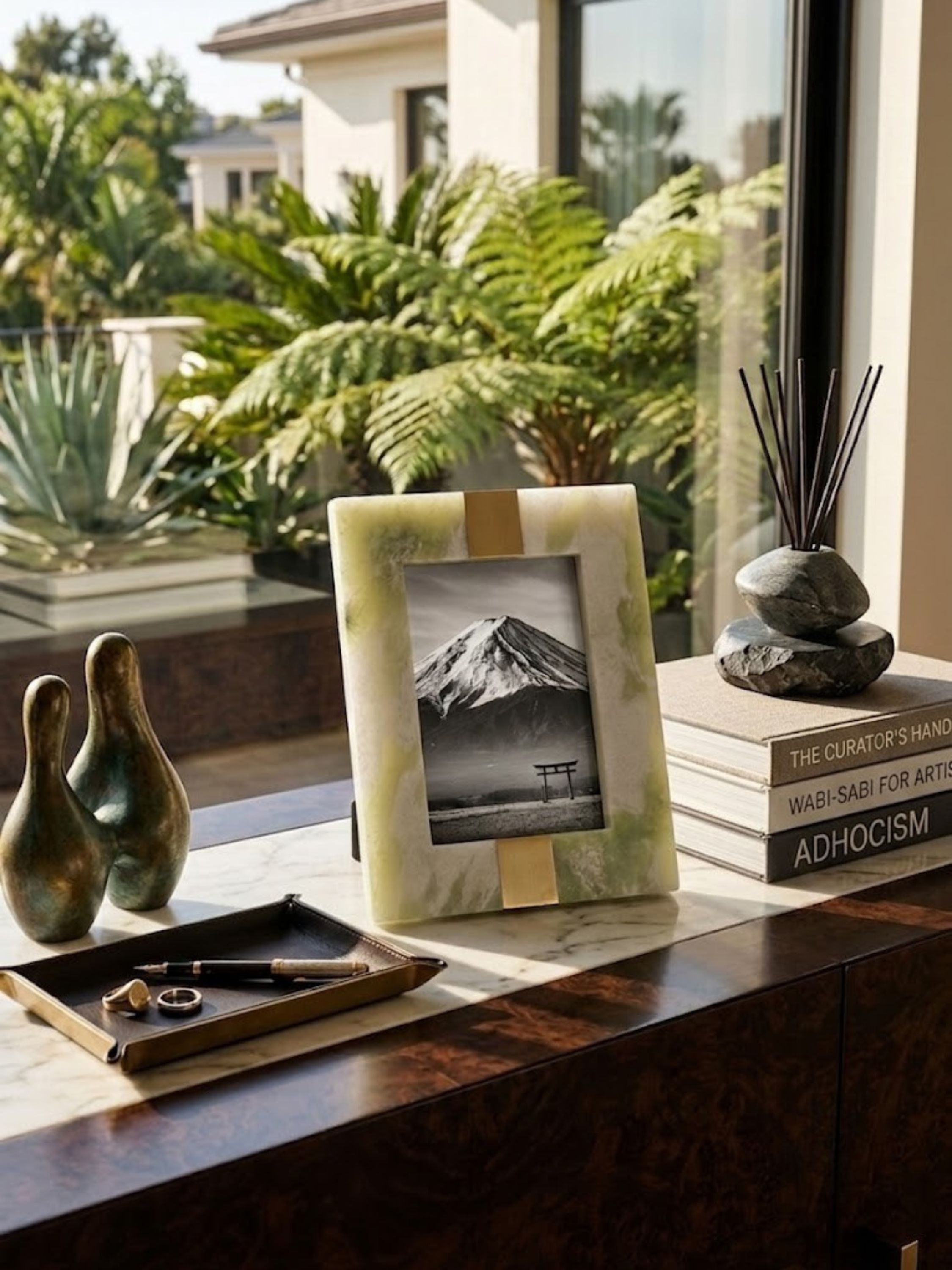 Green onyx picture frame with a wide border, styled on a console table.