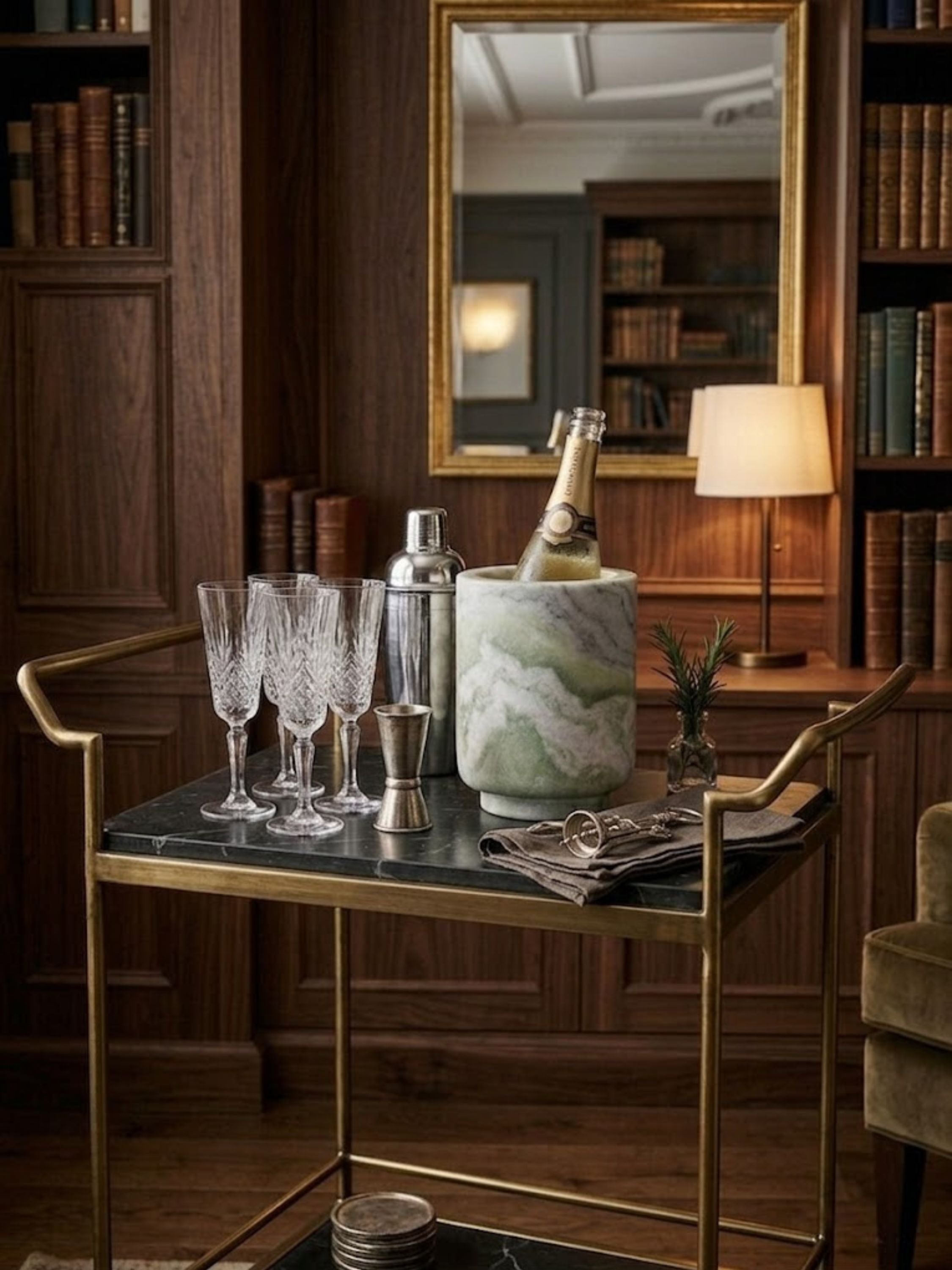 Chamonix green onyx wine cooler styled on a brass bar cart with crystal stemware and cocktail accessories.