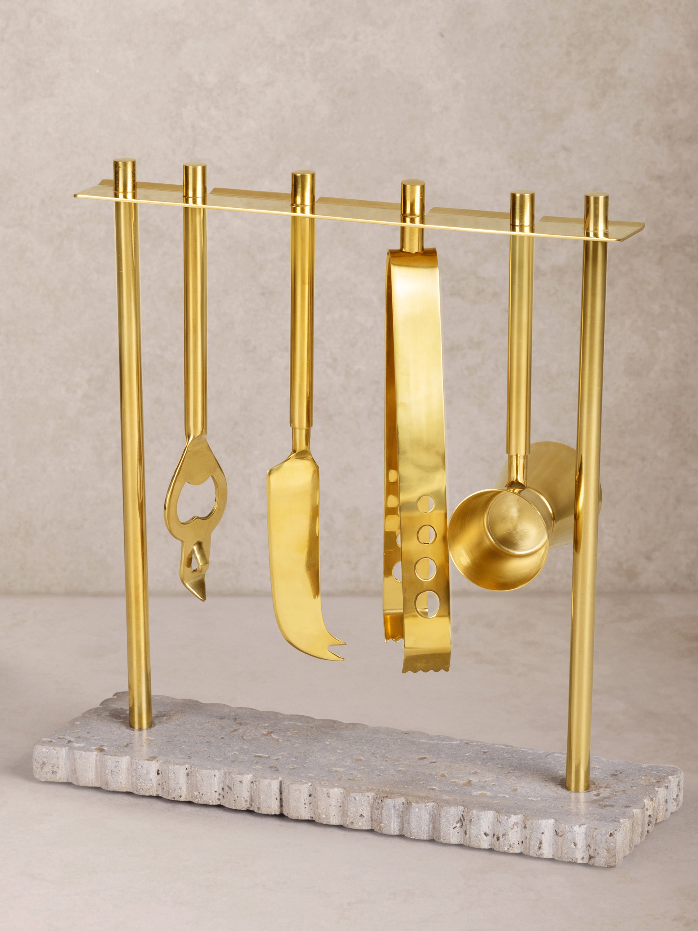 Jubel bar tool set on ribbed travertine base with gold tools