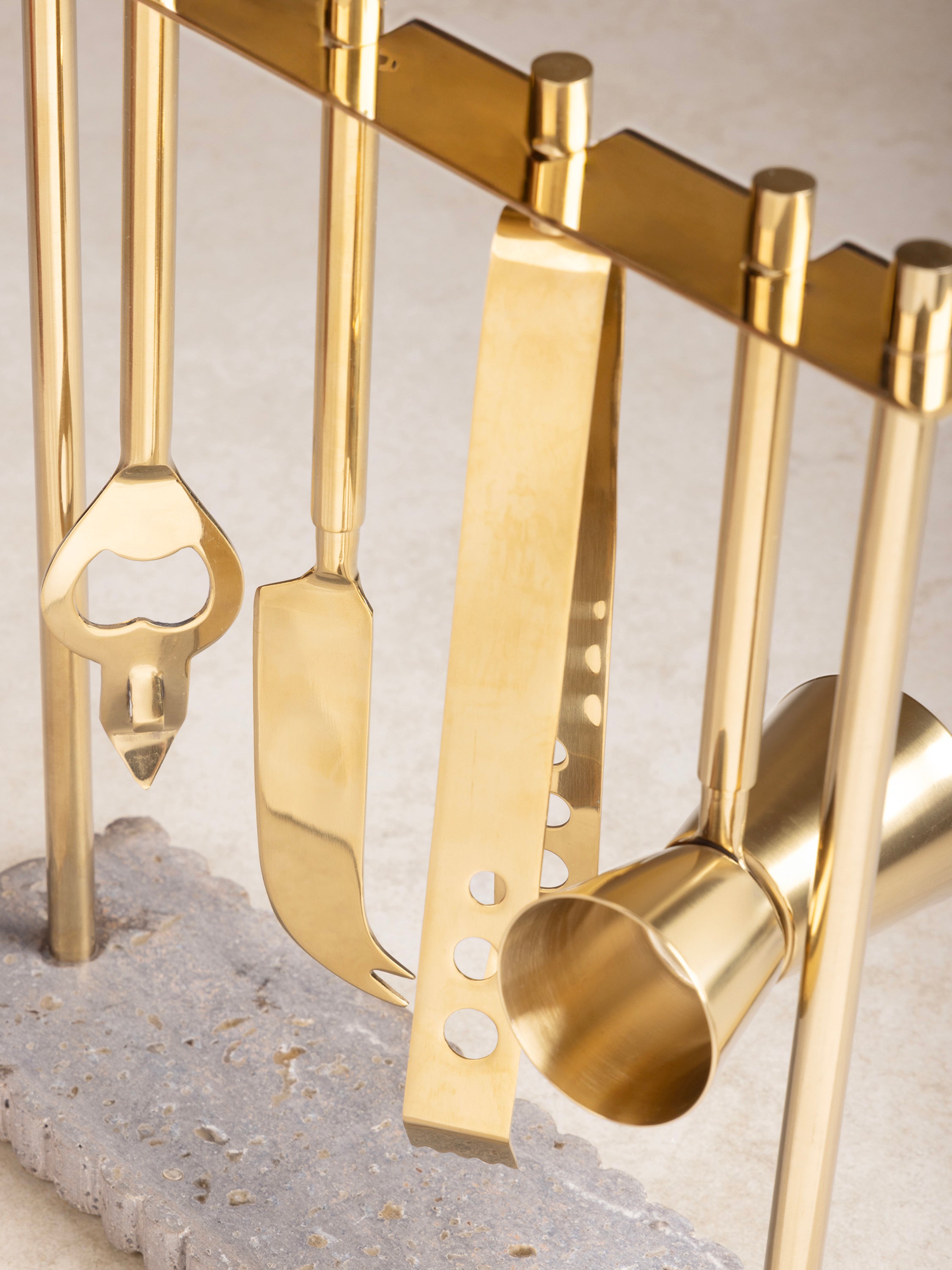 Close-up of ribbed travertine texture and gold-finish steel tools