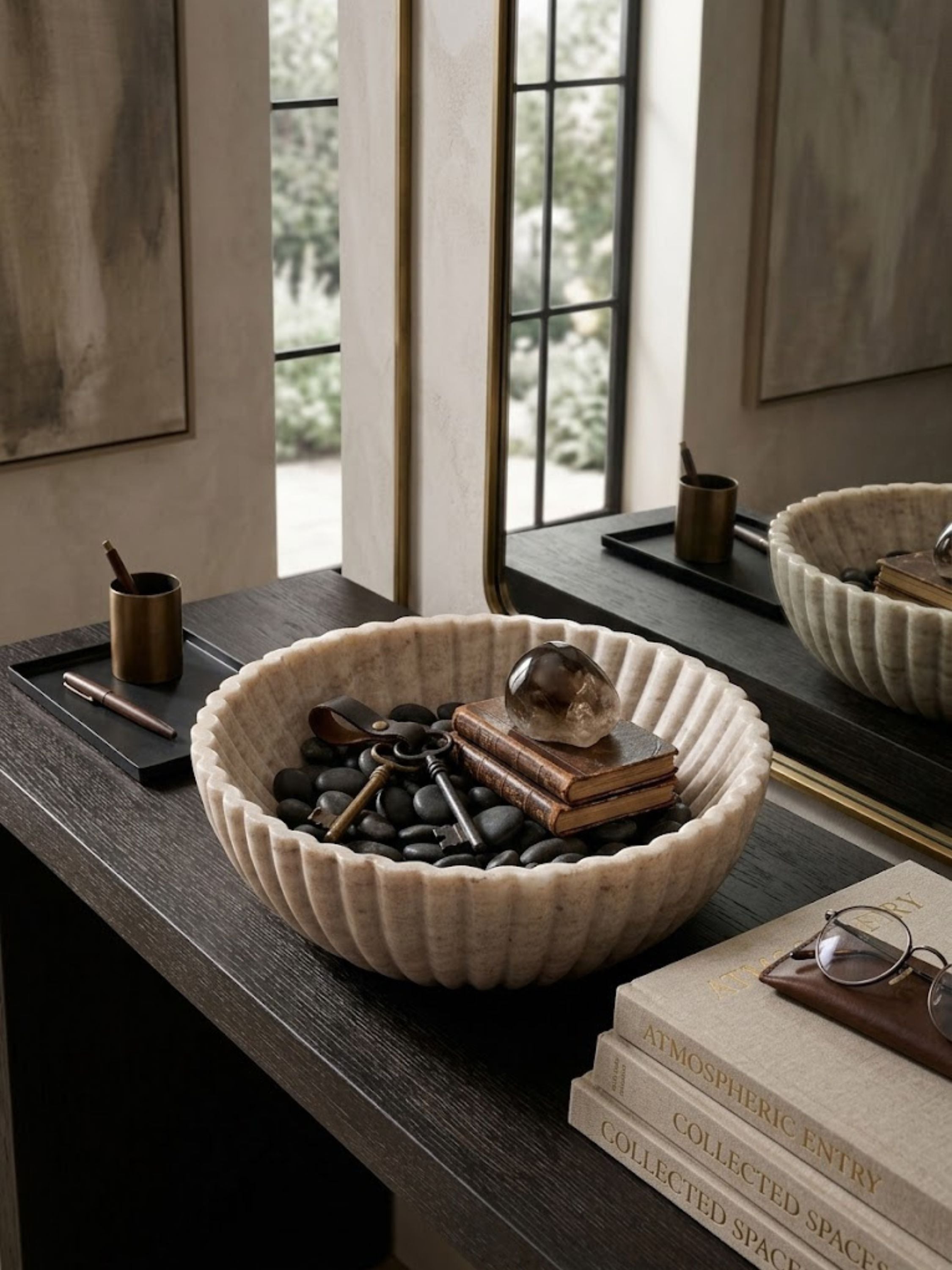 Ribbed beige onyx decorative bowl styled on an entryway console, layered with collected objects to highlight its sculptural form and softly veined stone character.