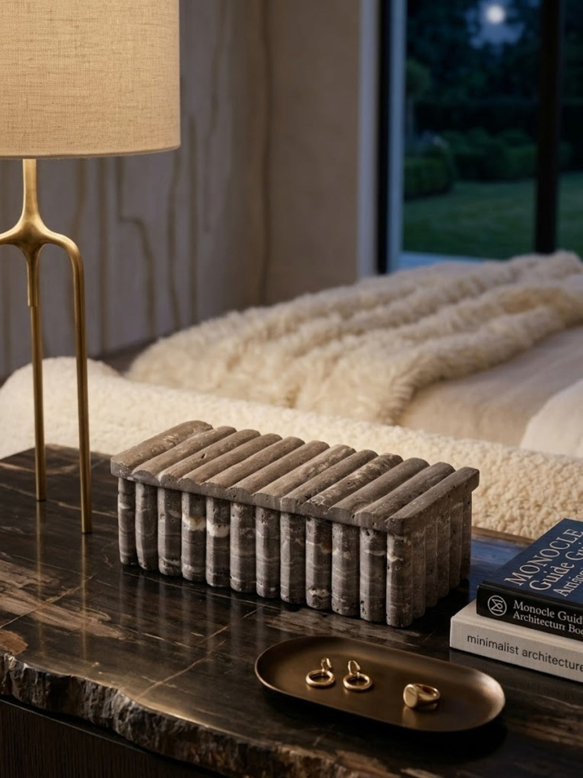 Gray travertine box with a ribbed lid, styled on a bedroom nightstand.