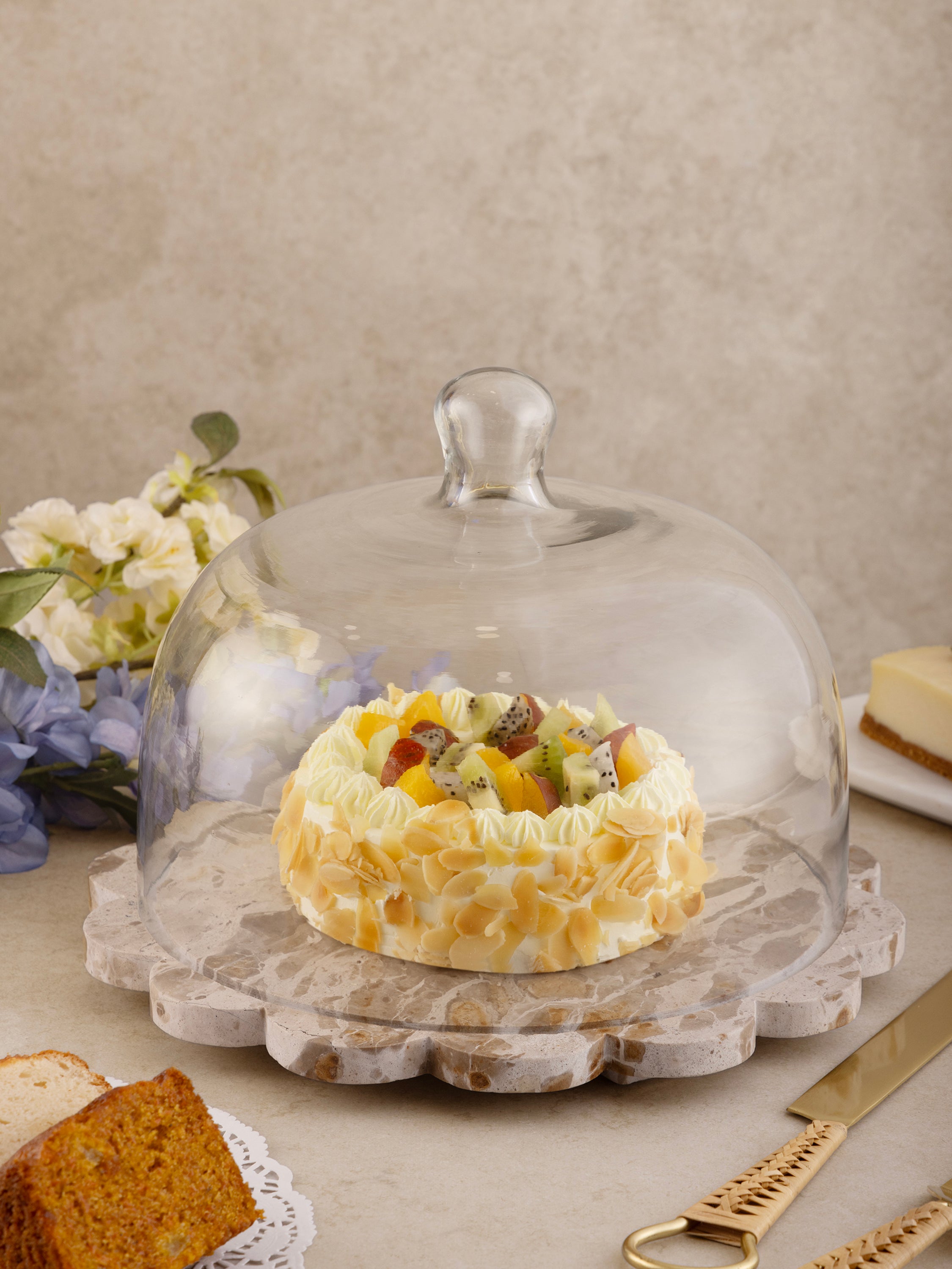 Serving board styled with cake under protective cloche