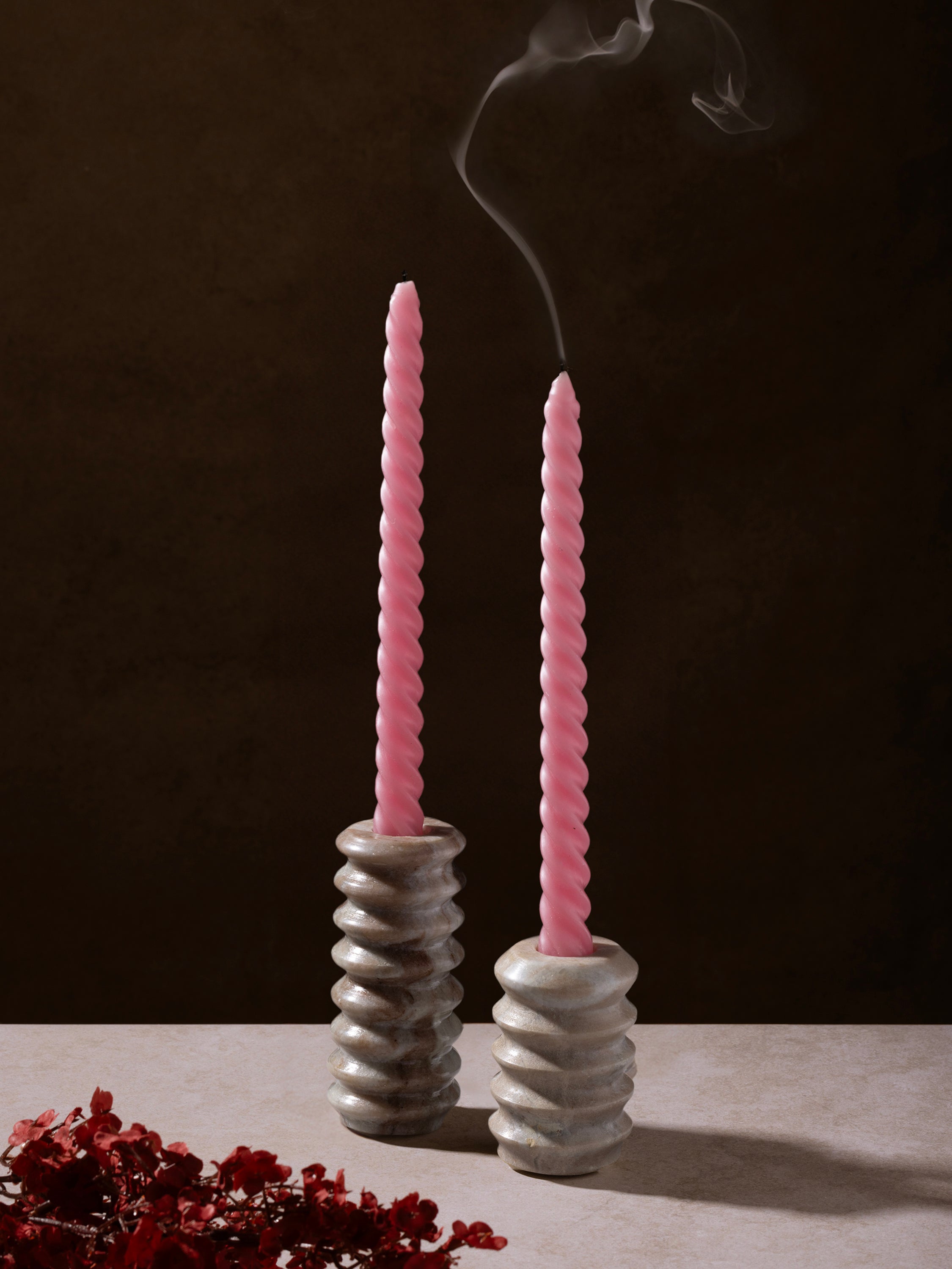 Pair of marble taper holders styled with lit candles