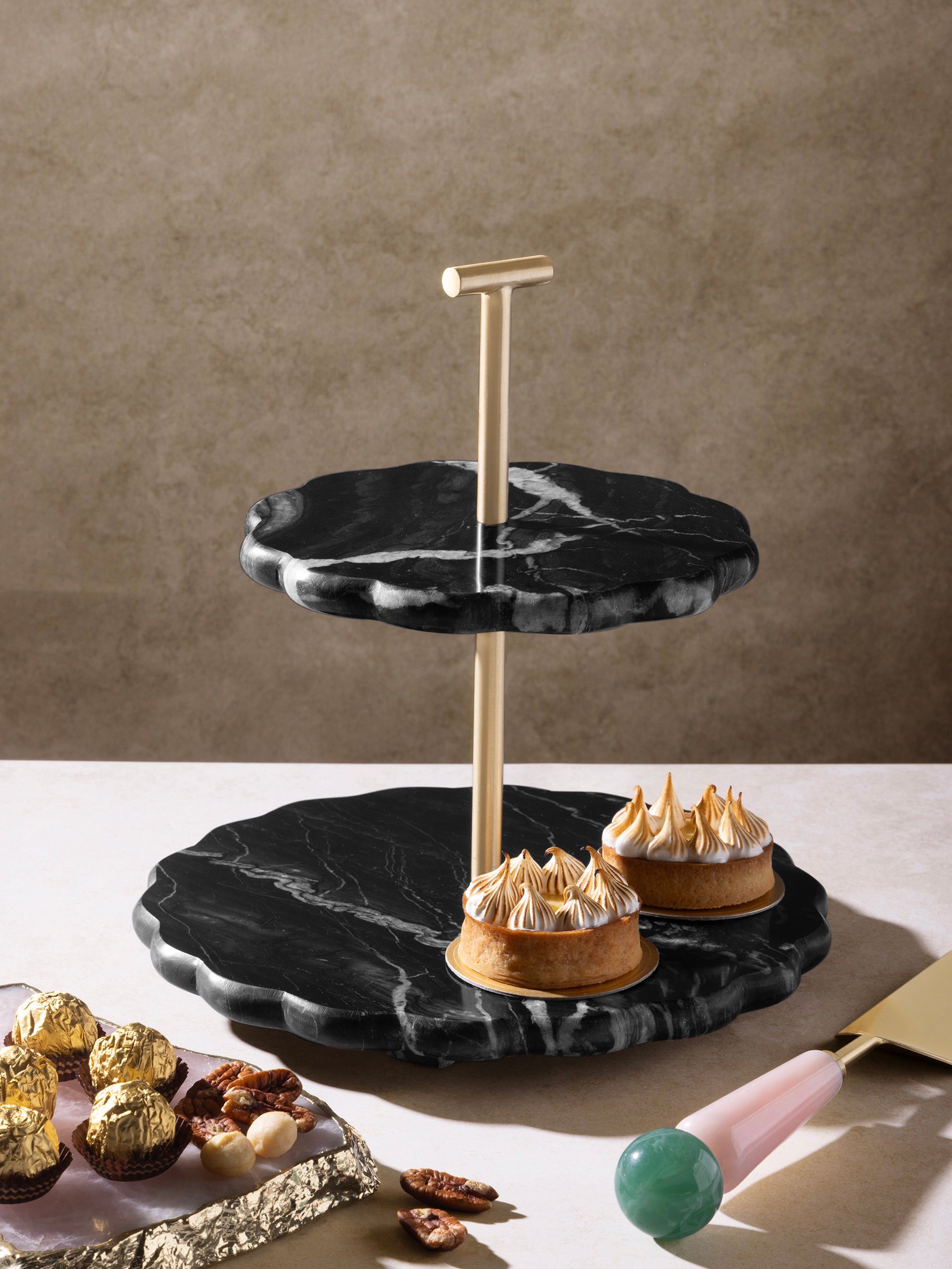 Black Marble and gold stand displaying cakes and desserts
