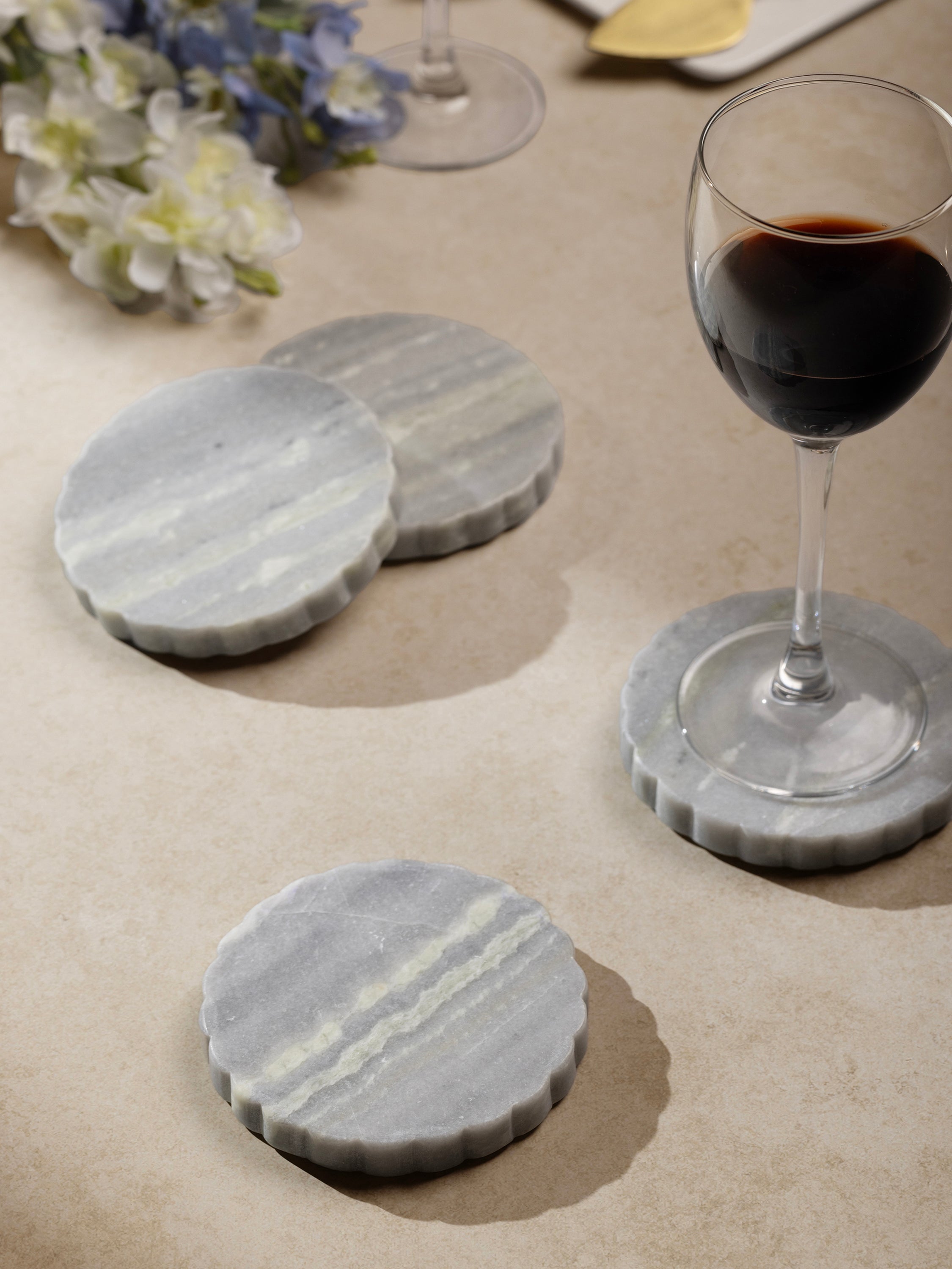 Coasters styled under wine glasses on a tabletop