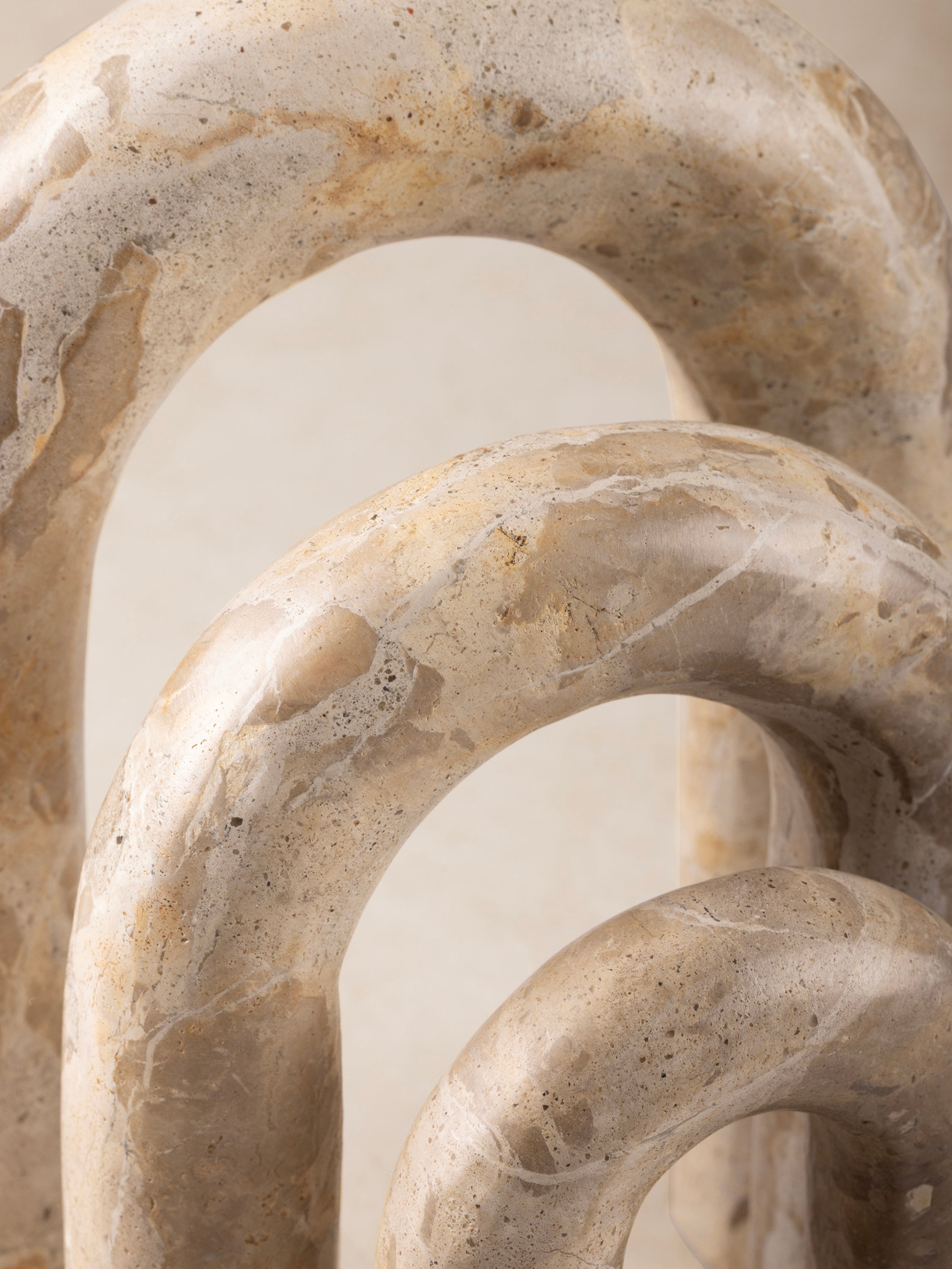 Close-up of a Jubilant onyx arch showing its smooth curved edges, hollow center, and layered natural veining.