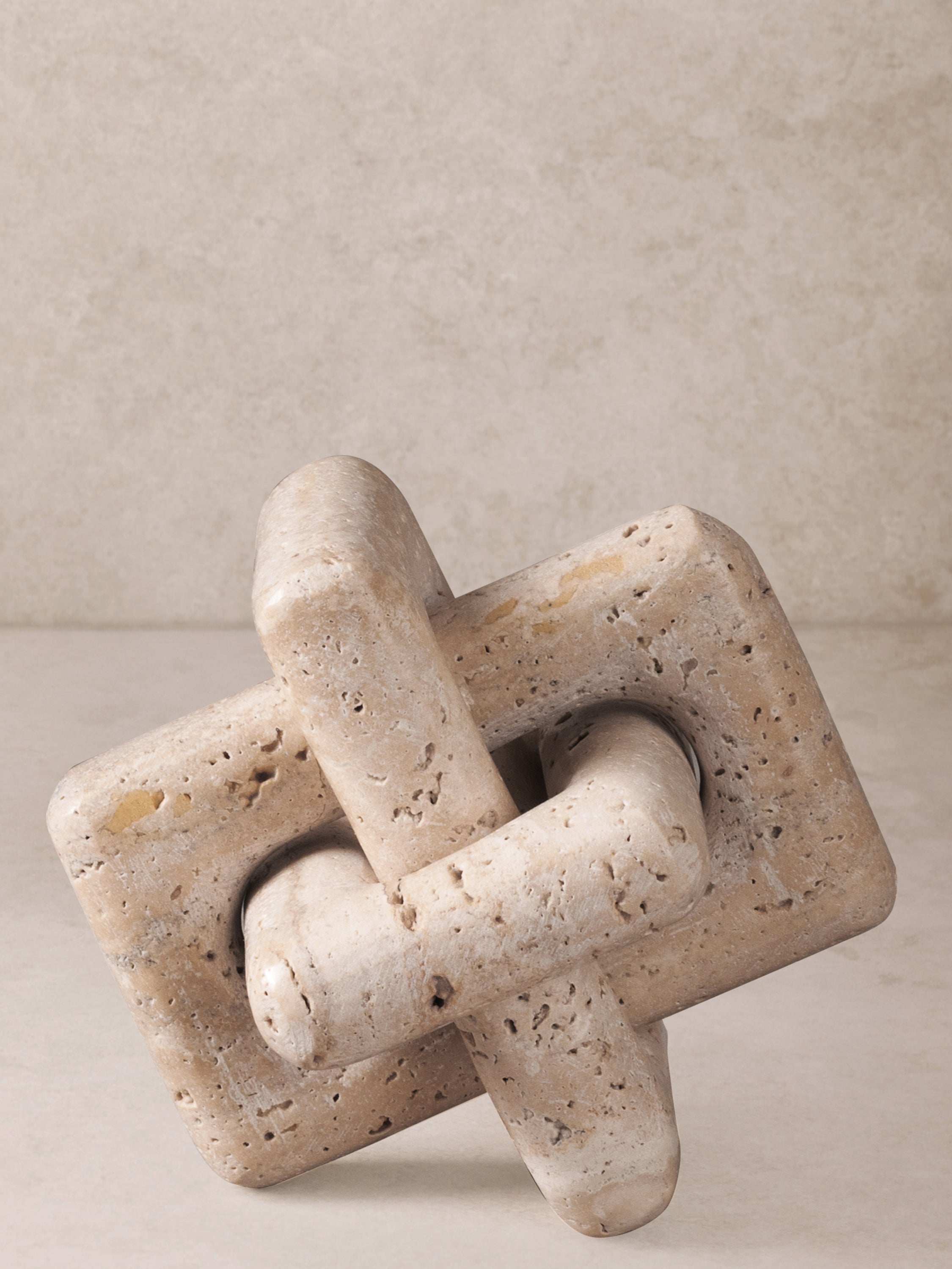 Knot sculpture styled on side table among decor items