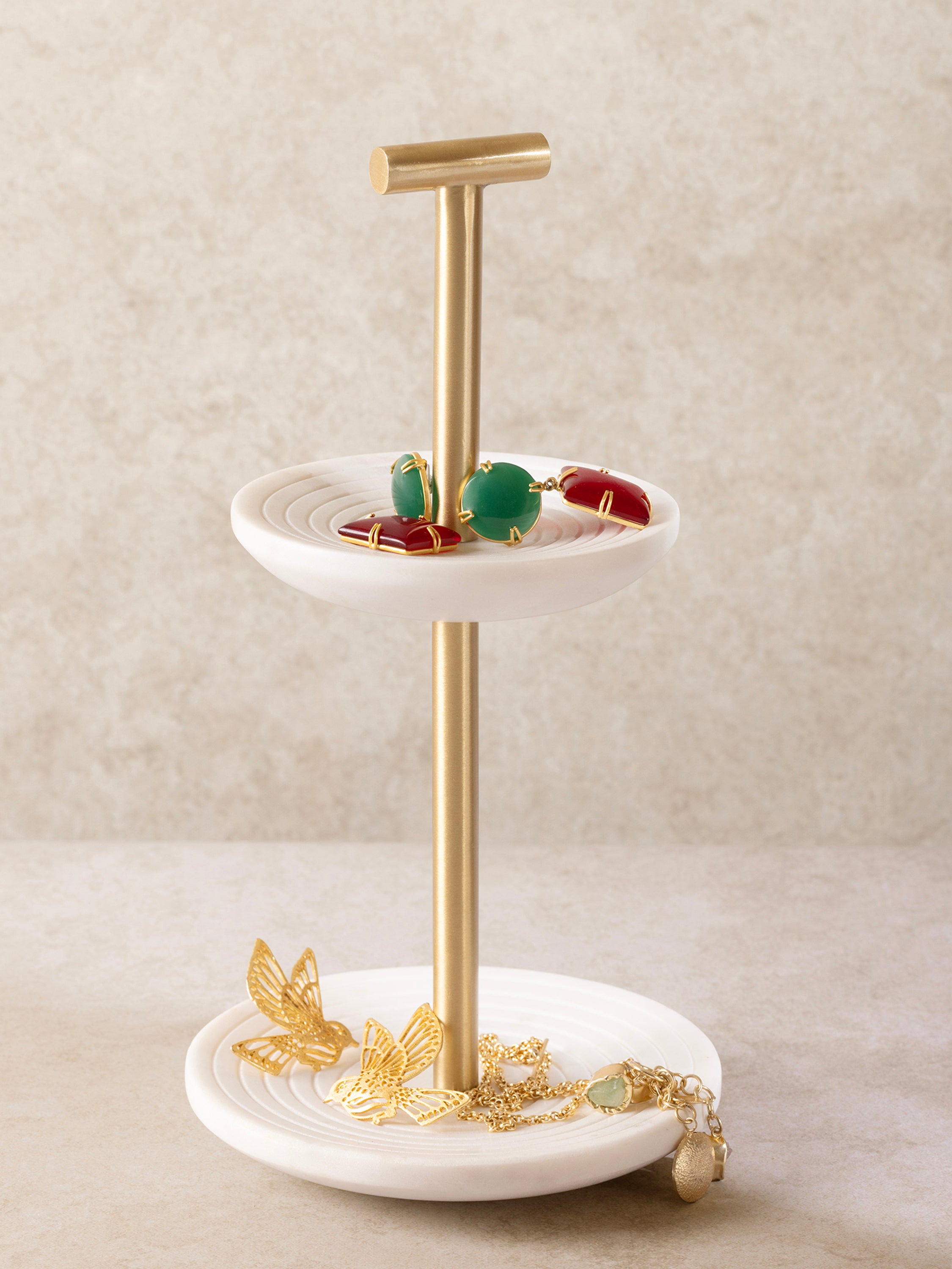 Jewelry stand on a vanity holding rings and bracelets