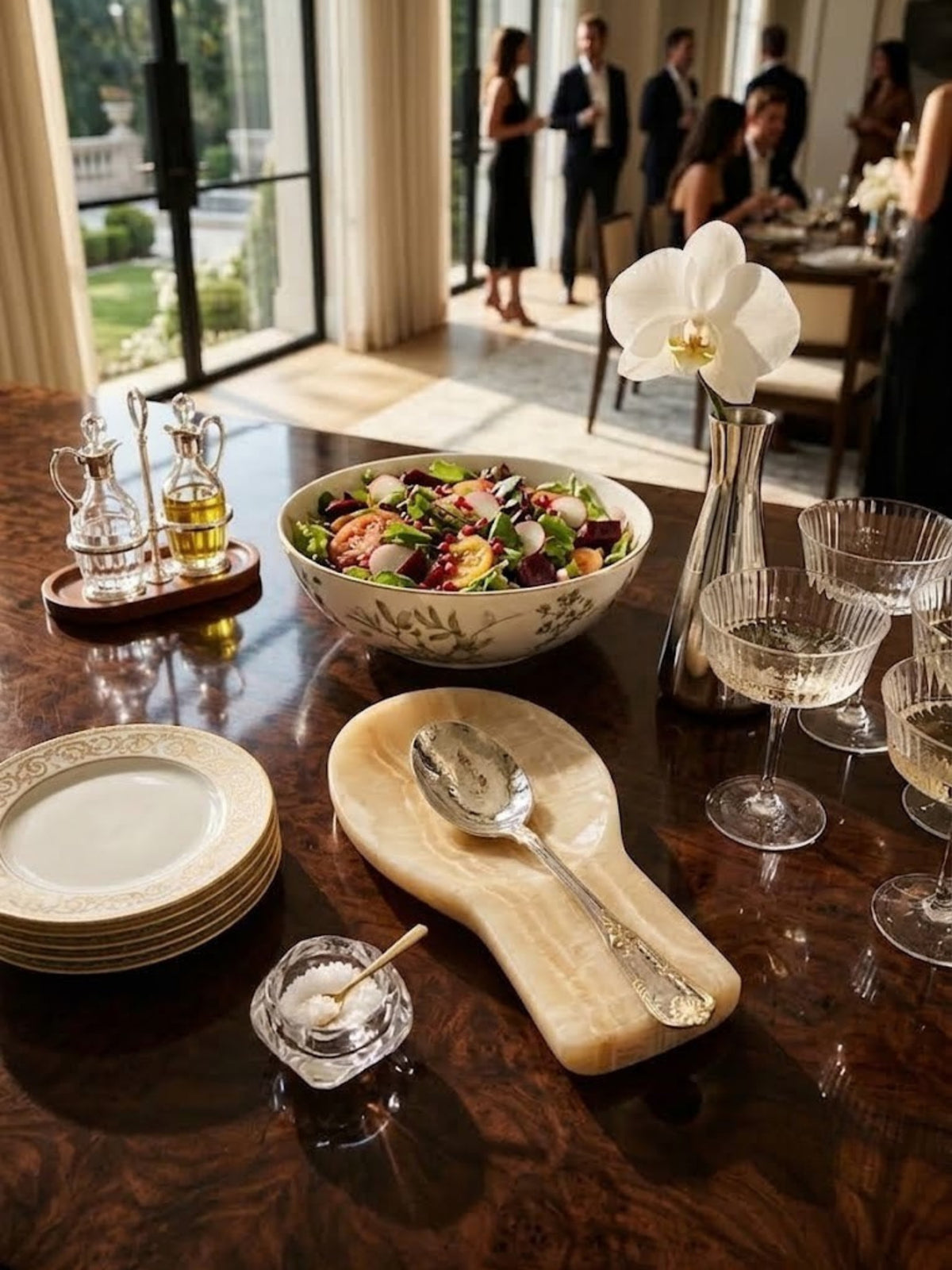 Machu Picchu onyx spoon rest holding a serving spoon on a dark wood dining table set for a meal.