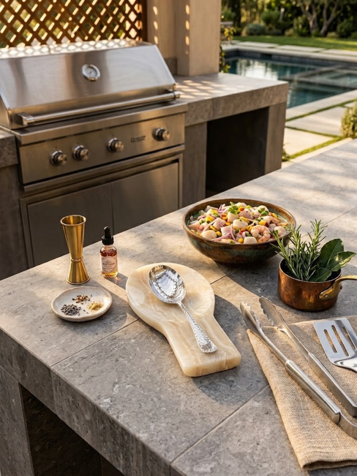 Machu Picchu onyx spoon rest on a stone counter in an outdoor kitchen beside a grill.