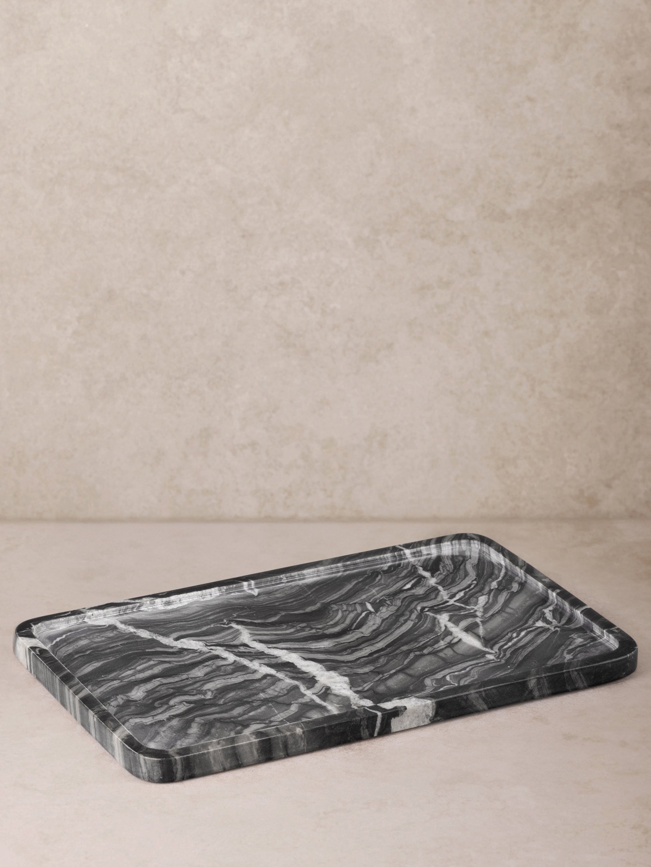 Close-up of polished black marble surface and scalloped edge of Frontier Tray
