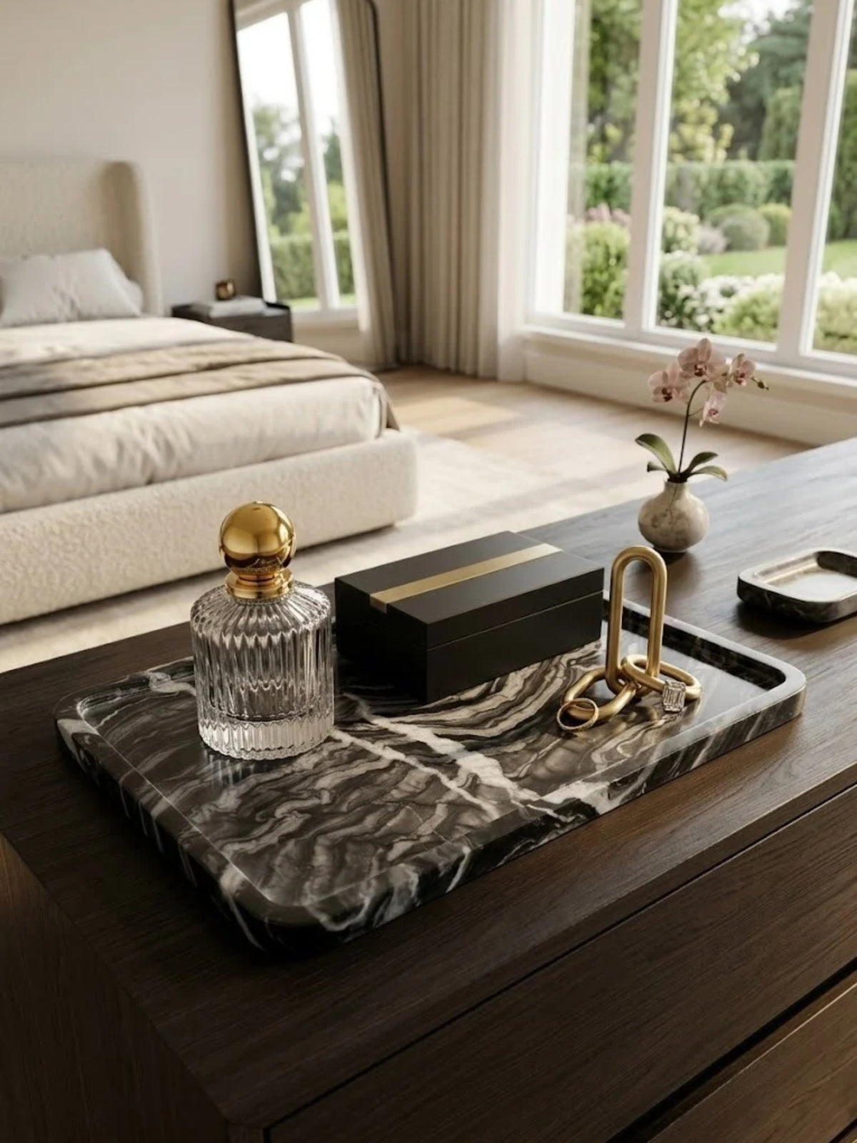 Frontier black onyx tray with gray veining, holding a decanter and valet box on a bedroom dresser.