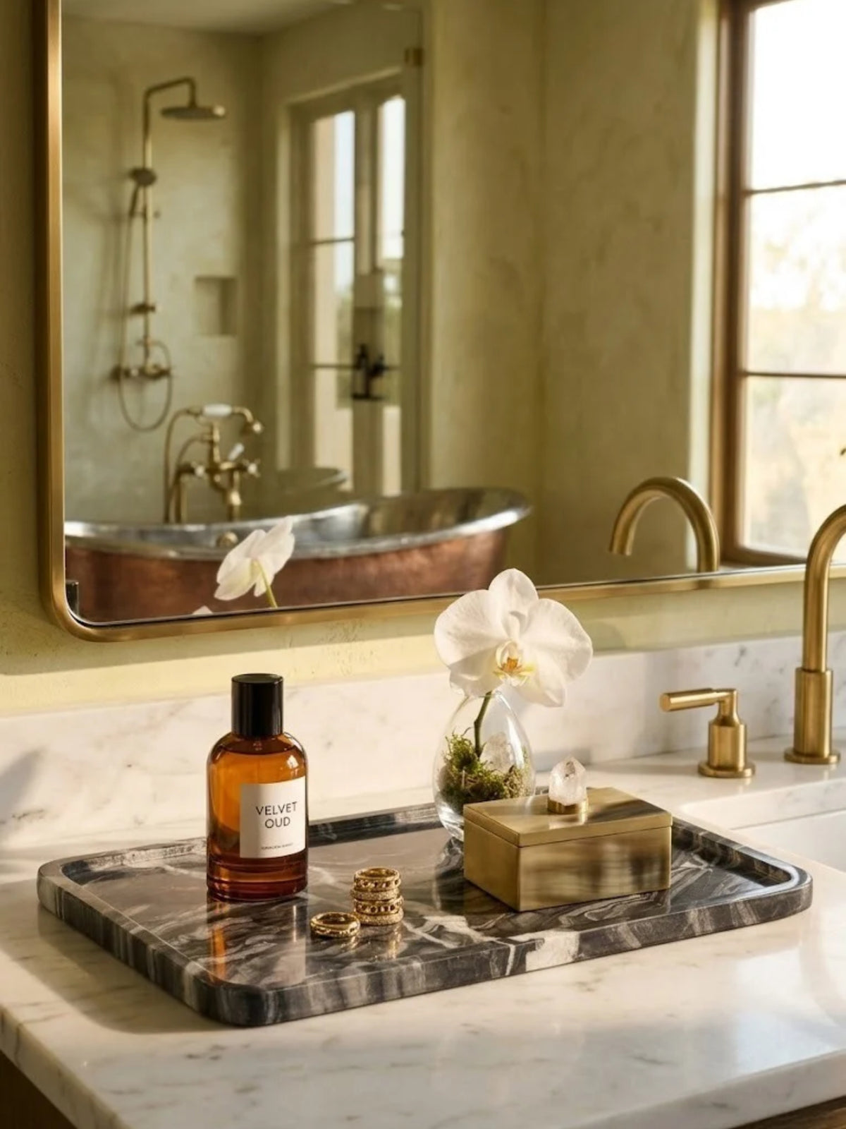 Frontier black onyx tray with gray veining, holding scent and rings on a bathroom vanity.