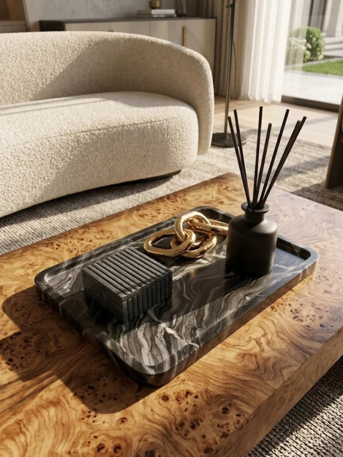 Frontier black onyx tray with gray veining, holding a reed diffuser on a living room coffee table.