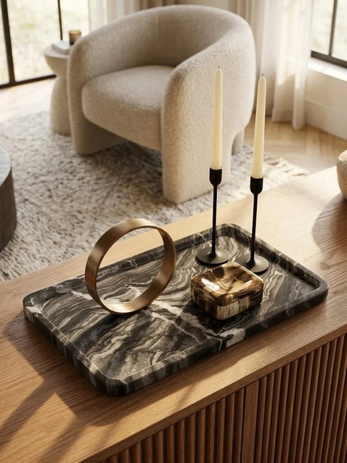 Frontier black onyx tray with gray veining, holding candles and a brass ring on a console table.