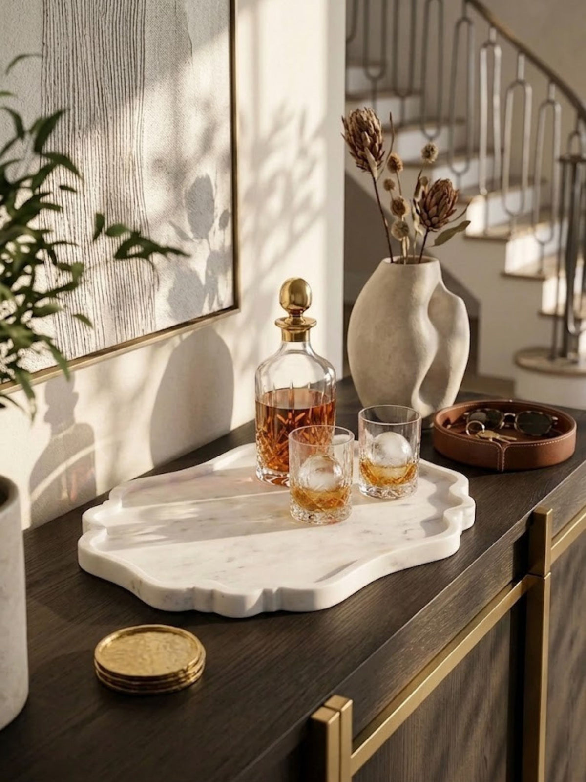 White marble tray with cartouche detailing, styled on an entryway landing.