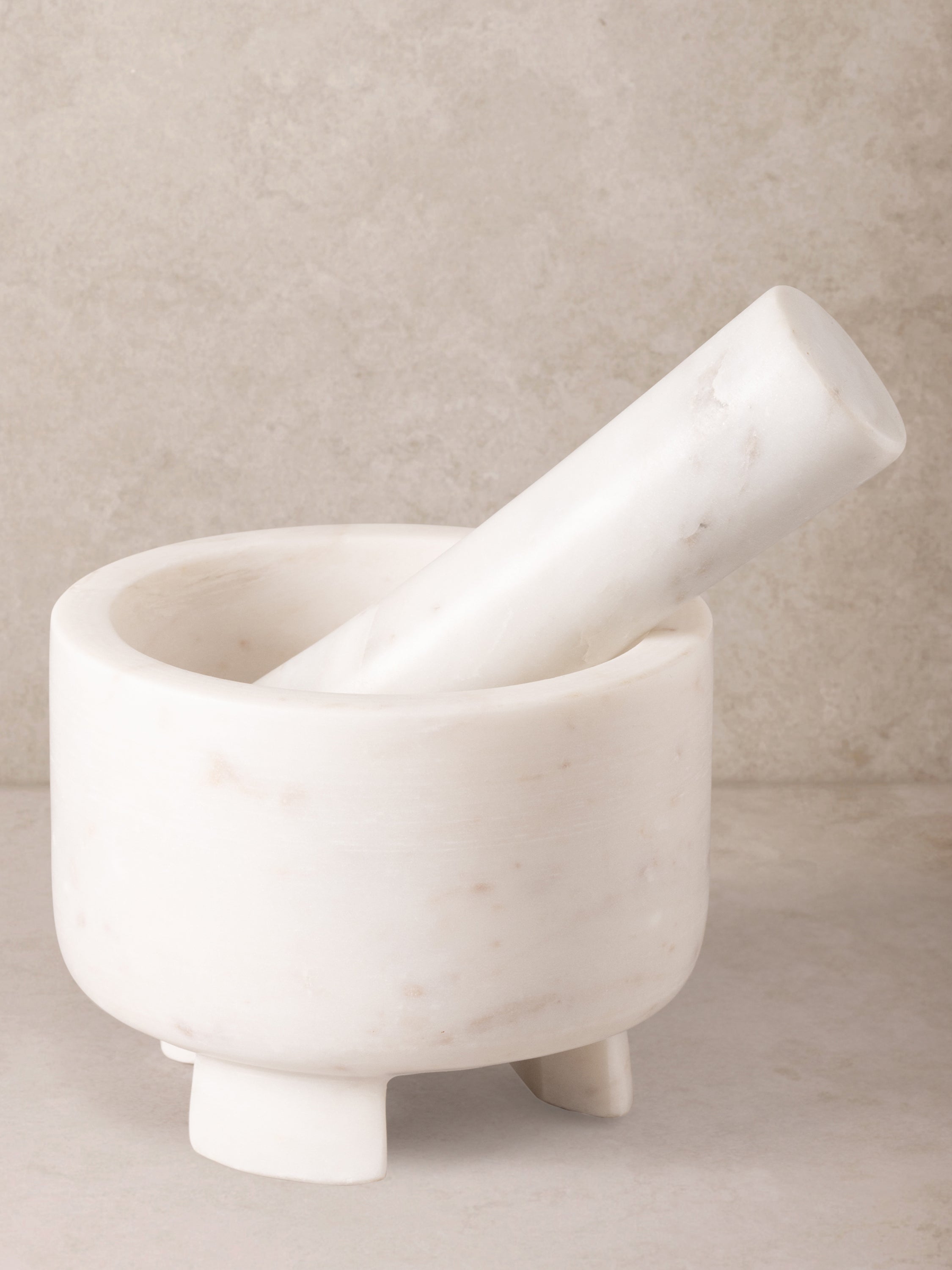 Odessa white marble mortar and pestle set on countertop