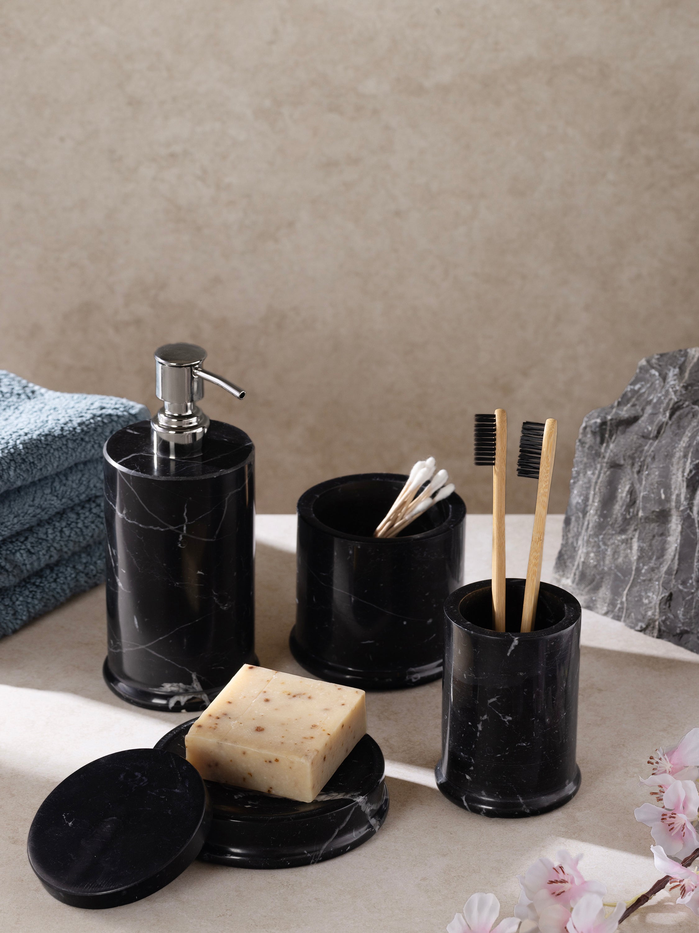 Marble bath accessories styled on luxury vanity with dark and white accents