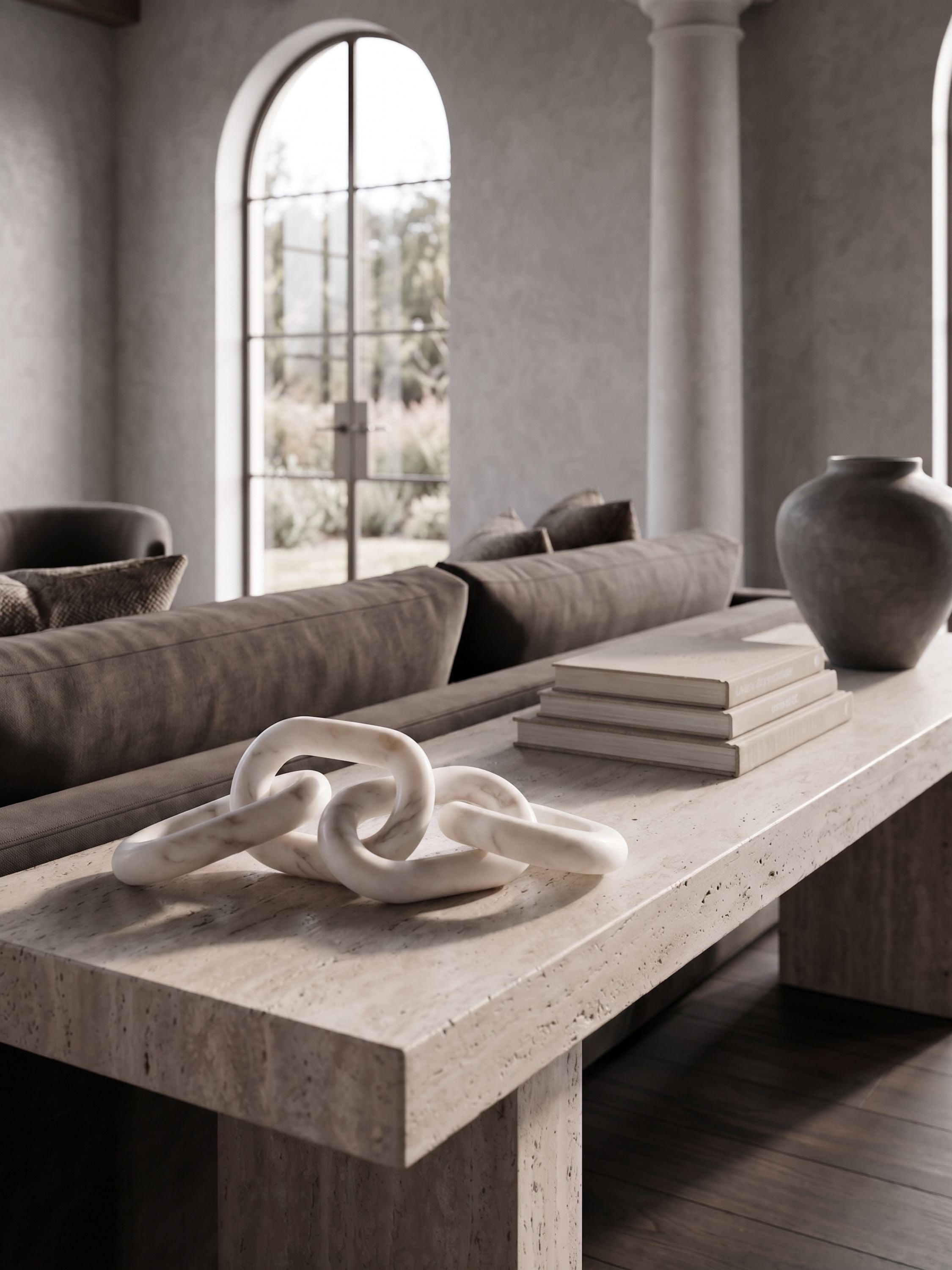 White marble chain link sculpture styled on a coffee table with books in a warm neutral living room