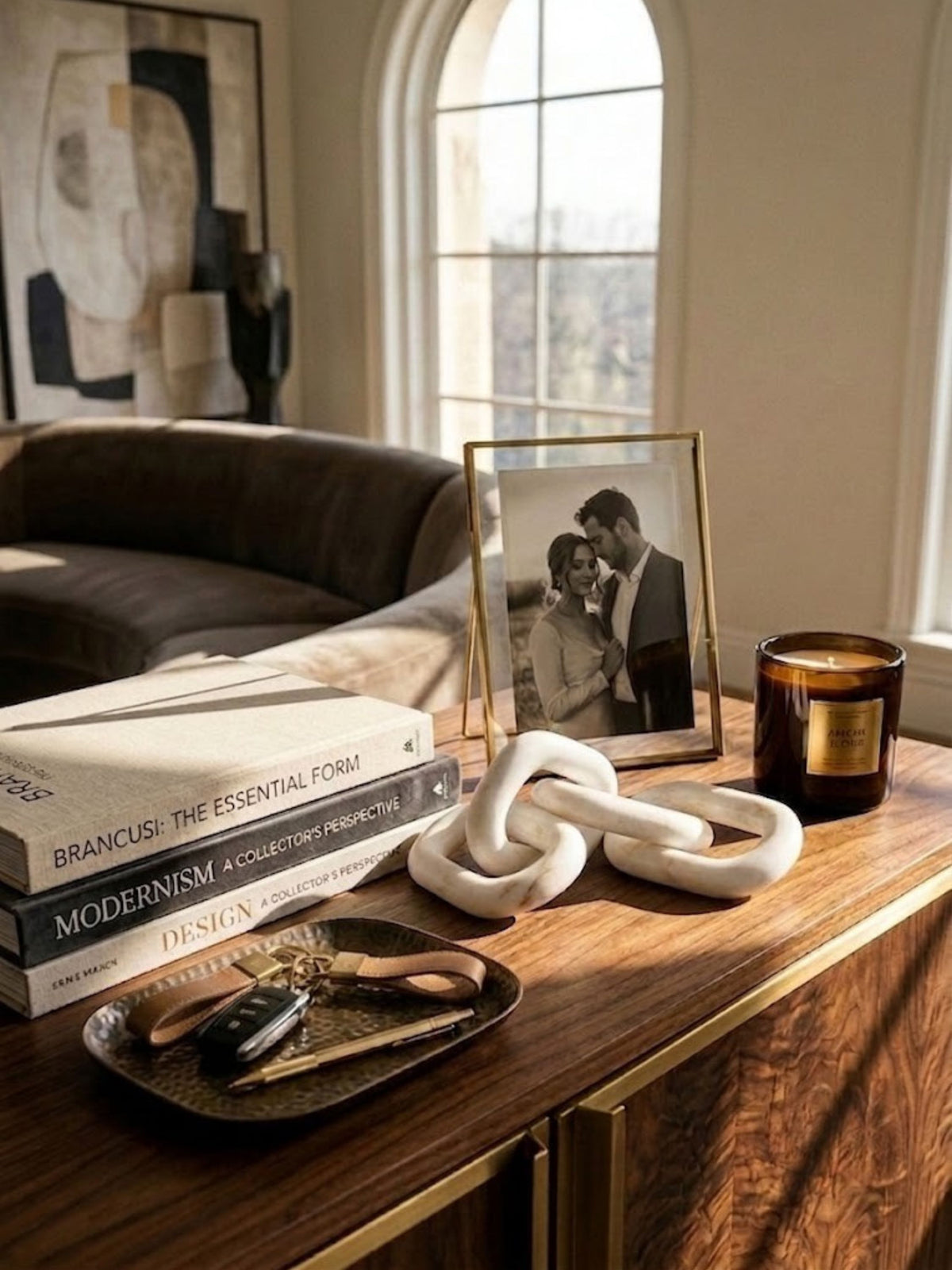 White marble chain-link sculpture styled on a living room console table.